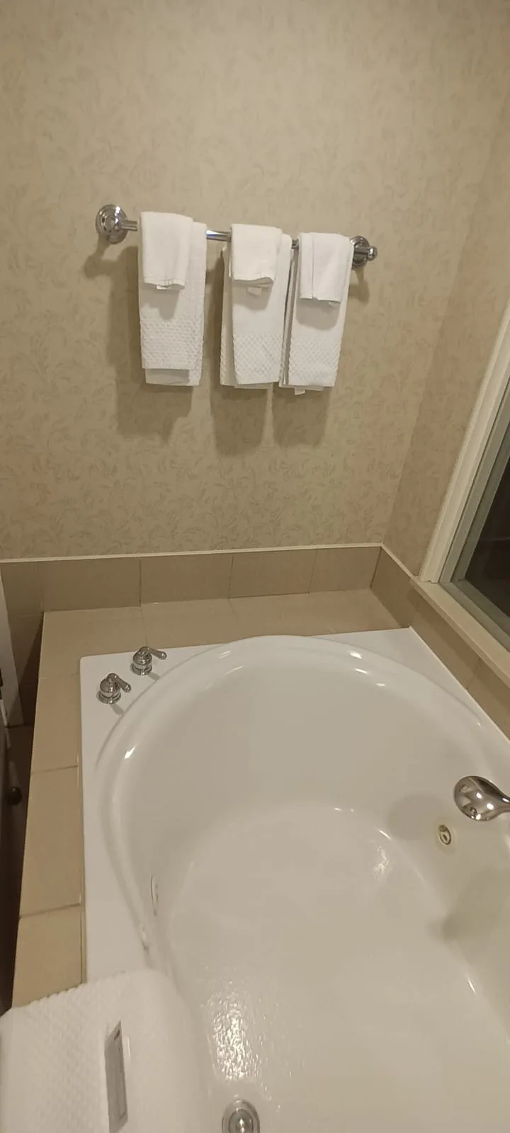 Hotelbad mit Badewanne und Handtüchern auf Handtuchhalter