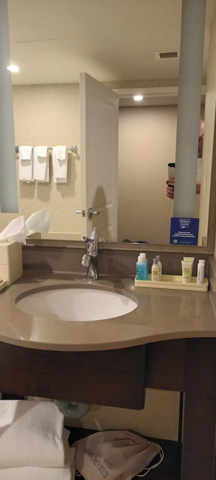 Hotelbadezimmer mit Waschbecken, Spiegel und Handtüchern