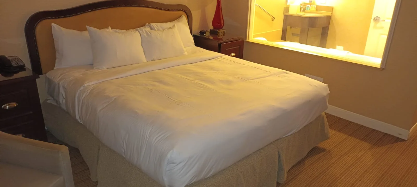 Hotelzimmer mit Doppelbett und grauem Tagesdeckenbezug