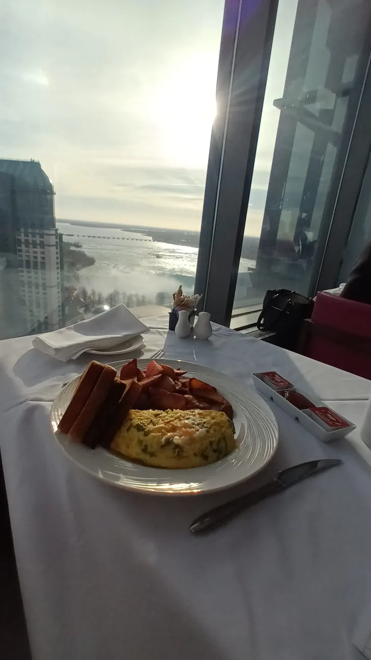 Frühstücksteller mit Omelett und Speck auf Tisch mit Blick auf Niagara-Fälle