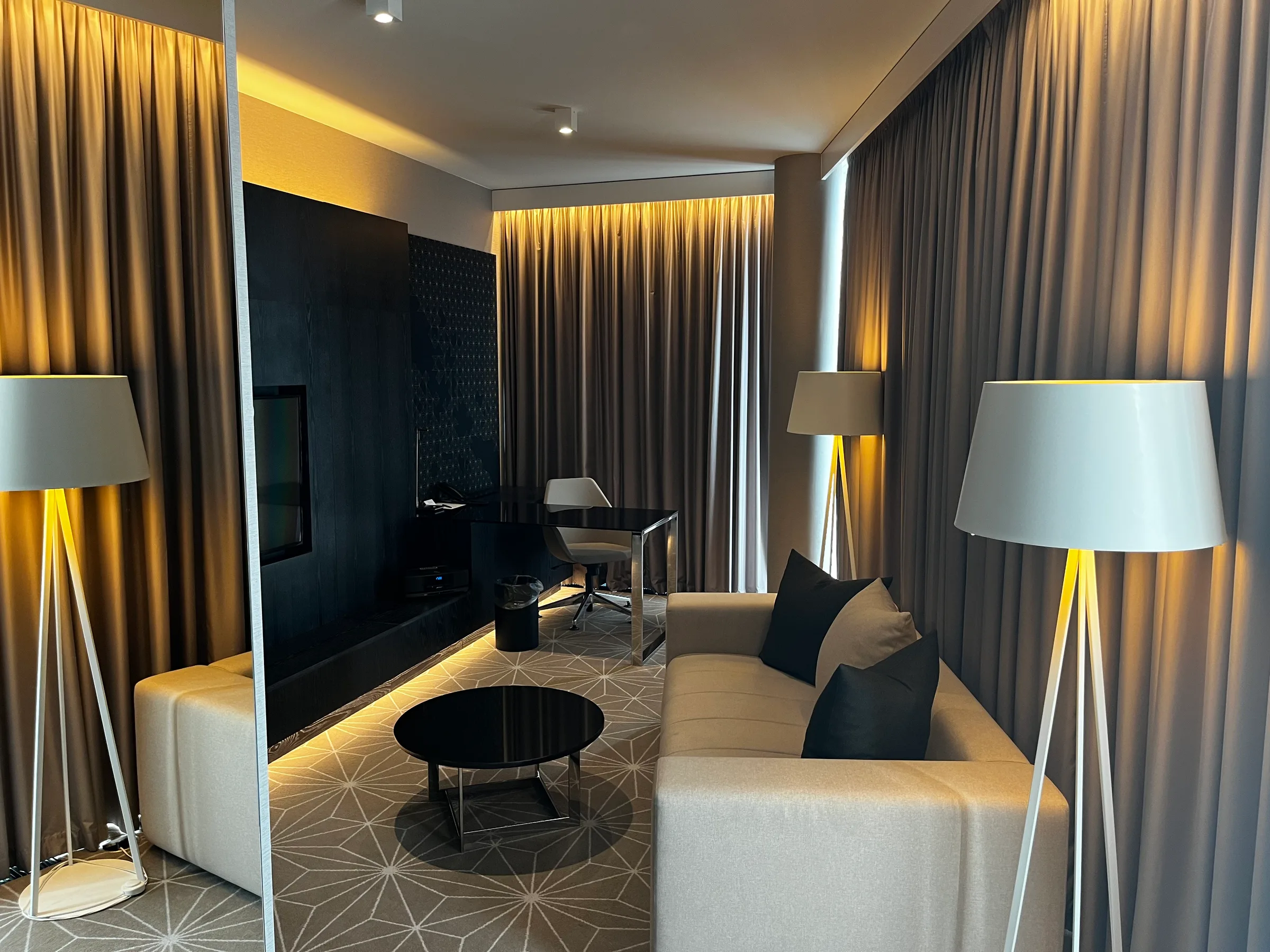 Hotelzimmer mit Couch, Sessel und Stehlampen