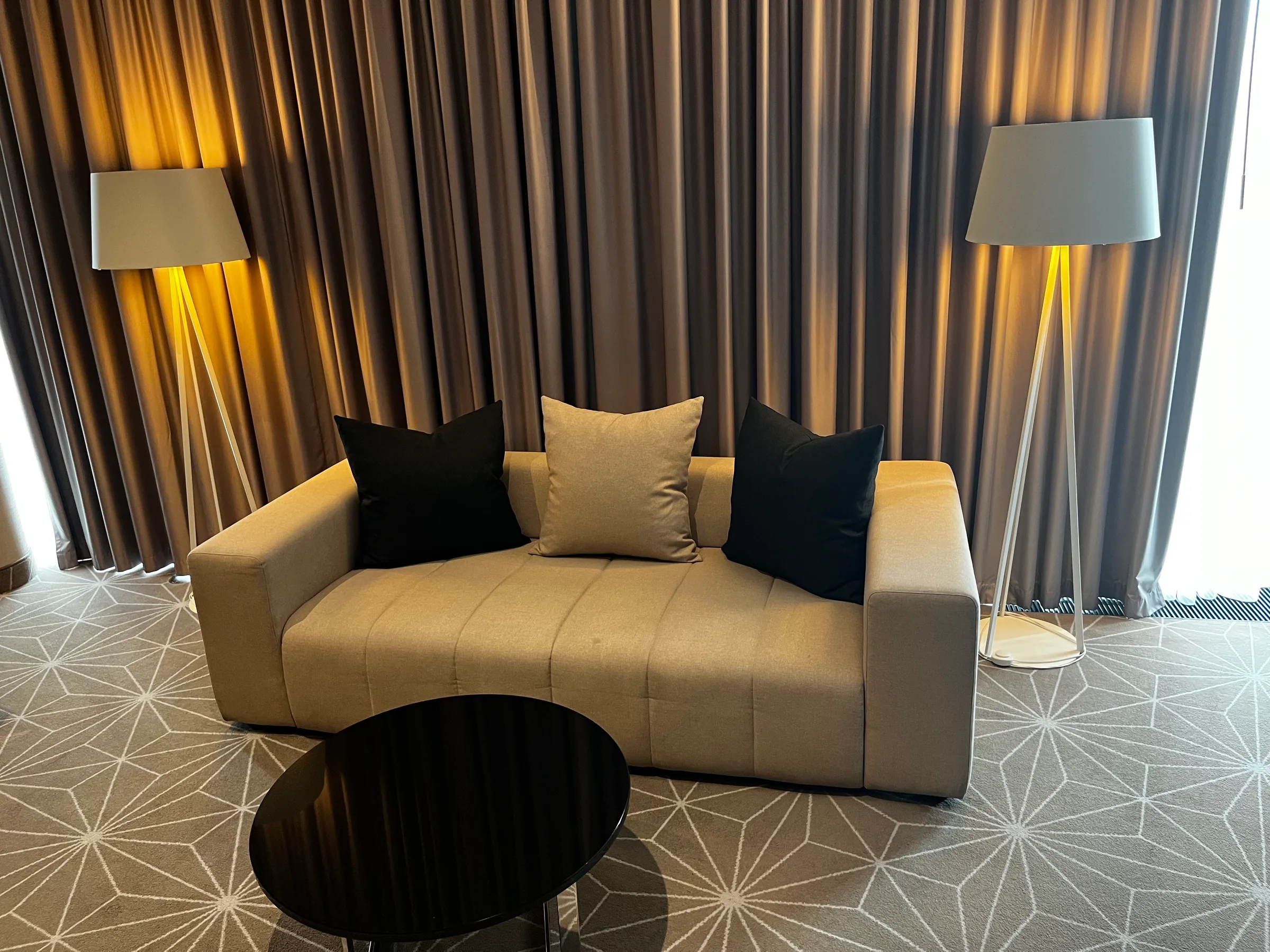 Hotelzimmer mit Couch und Kissen in warmen Farbtönen