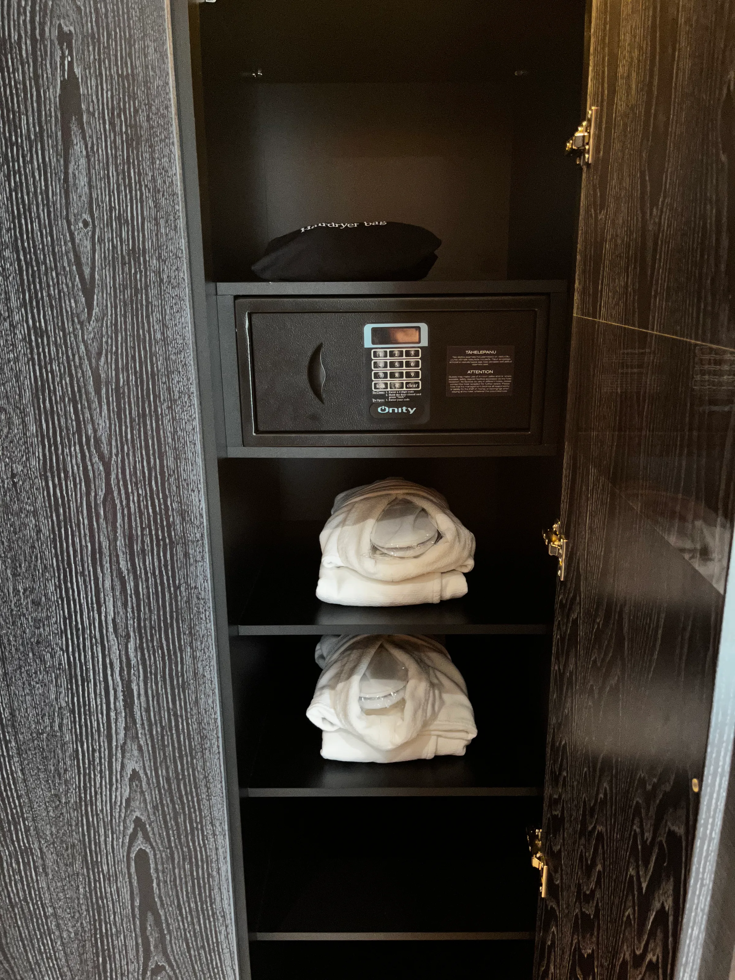 Schrank mit Safe und Handtüchern im Hotelzimmer