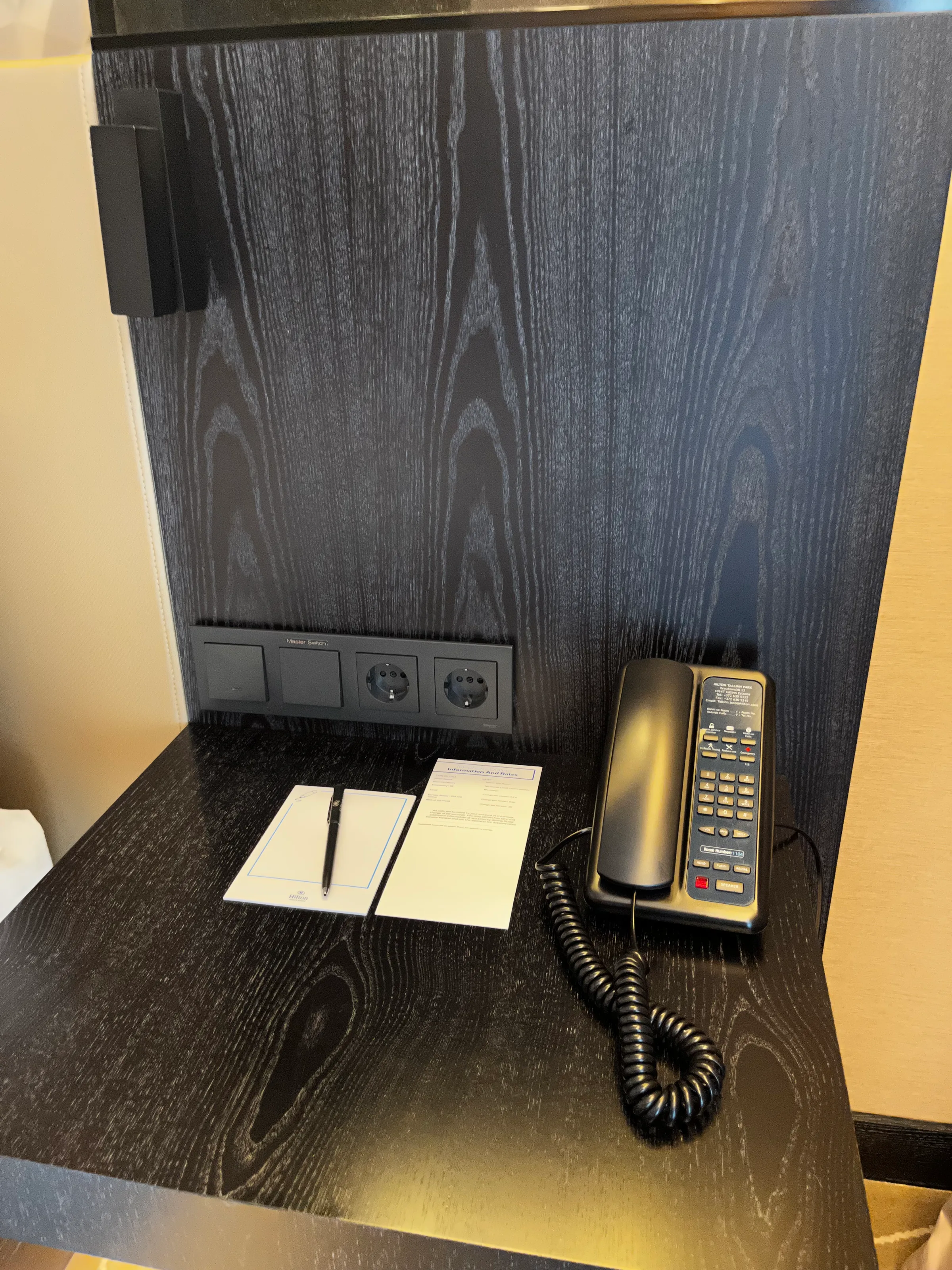 Hotelzimmer mit Telefon und Notizblock auf Holztisch