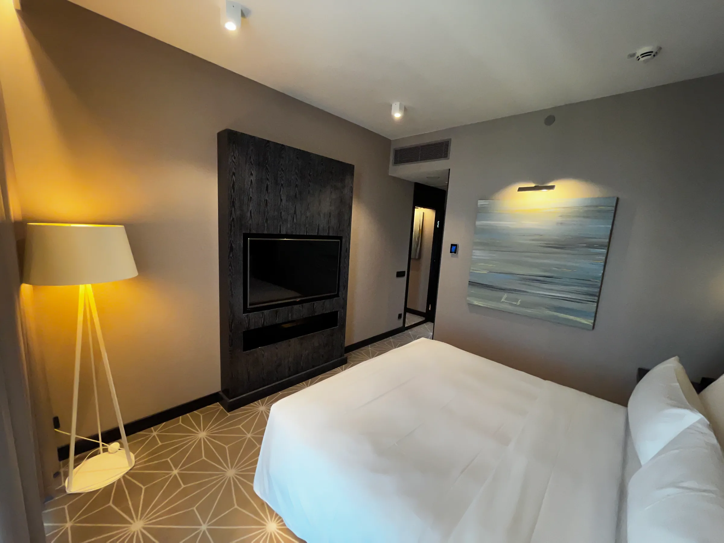 Hotelzimmer mit Doppelbett und Flachbildfernseher an der Wand