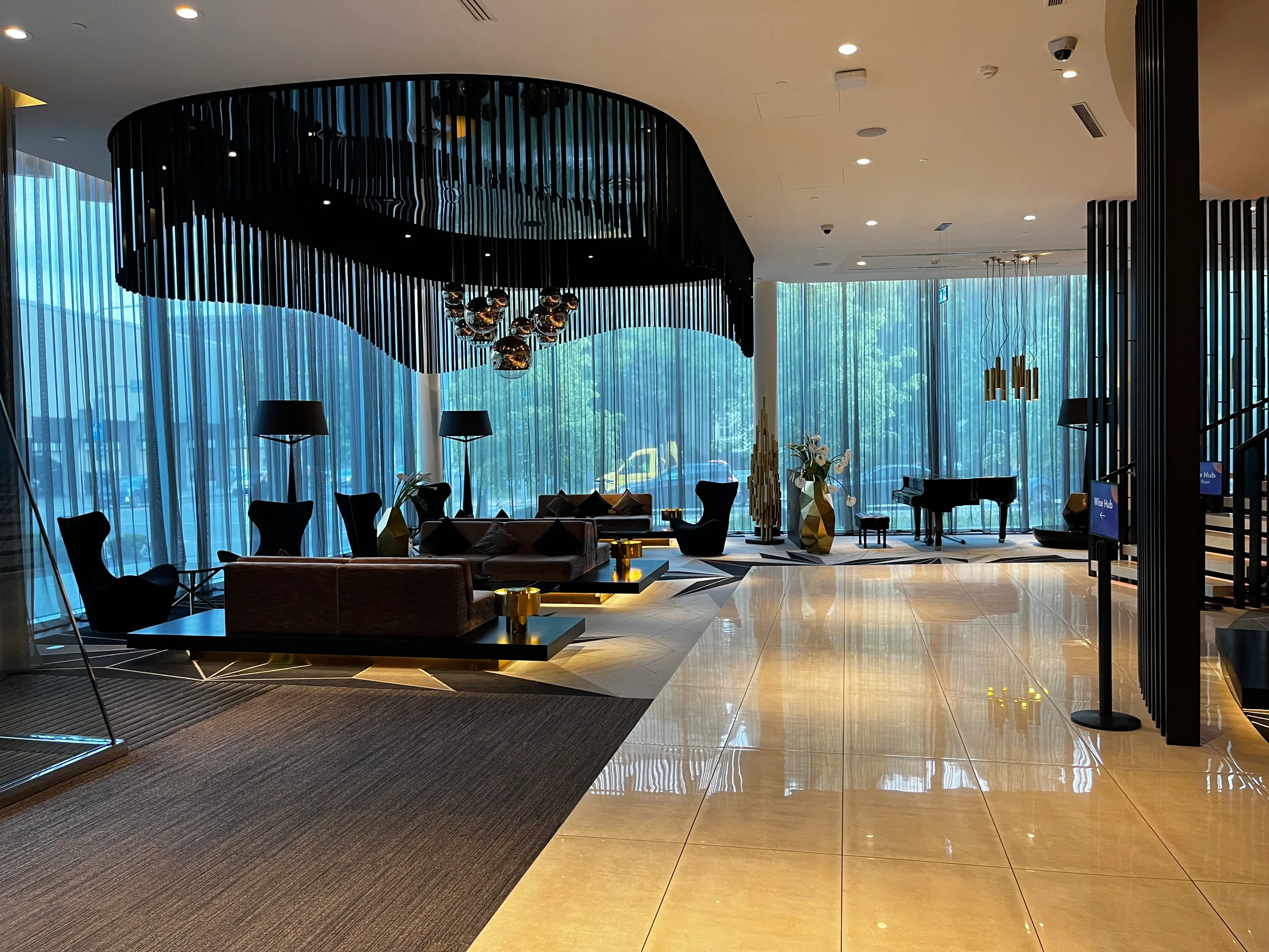 Lobby eines Hotels mit moderner Einrichtung und großen Fenstern