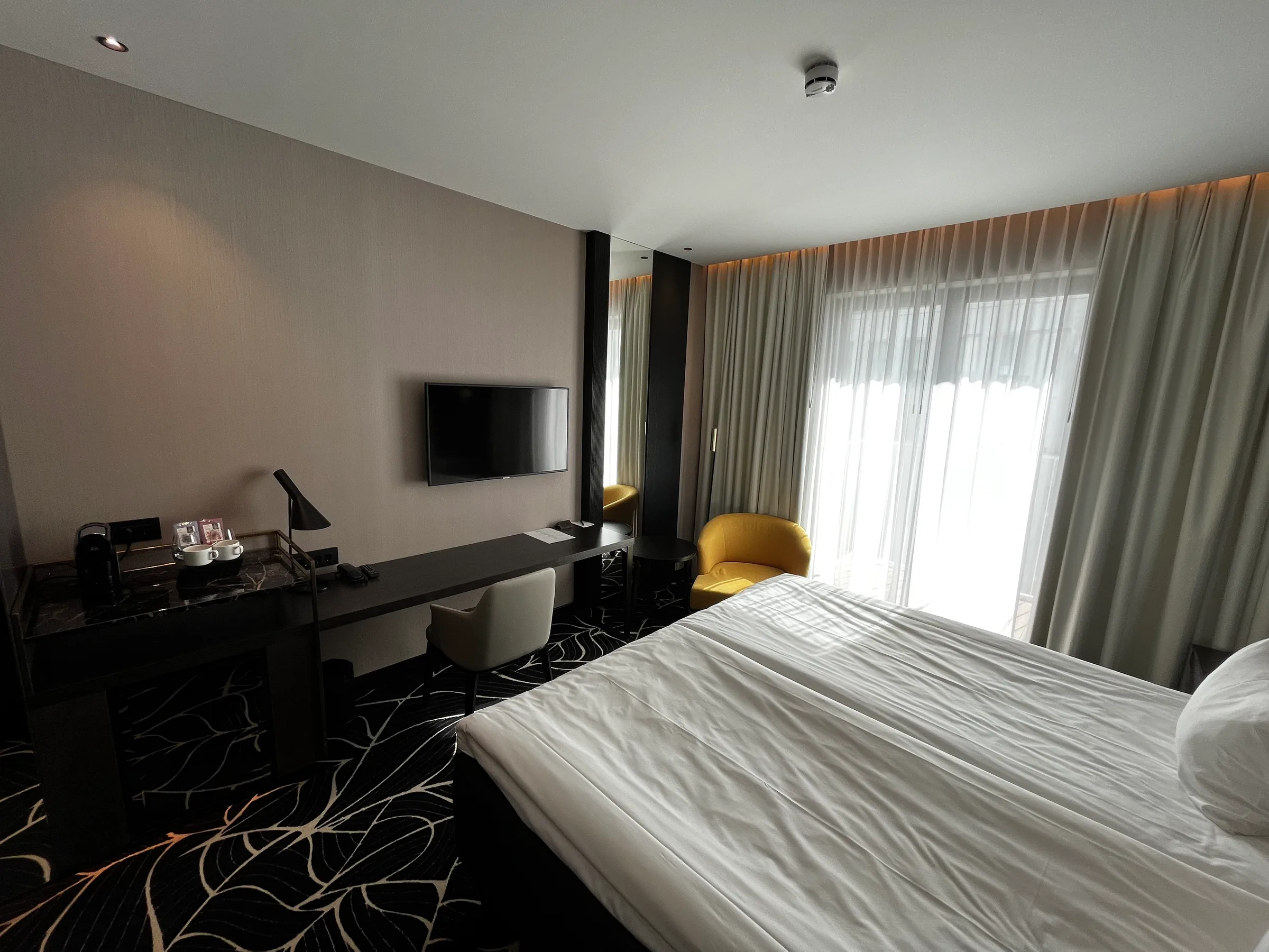 Hotelzimmer mit Doppelbett und Schreibtisch in neutralen Farben