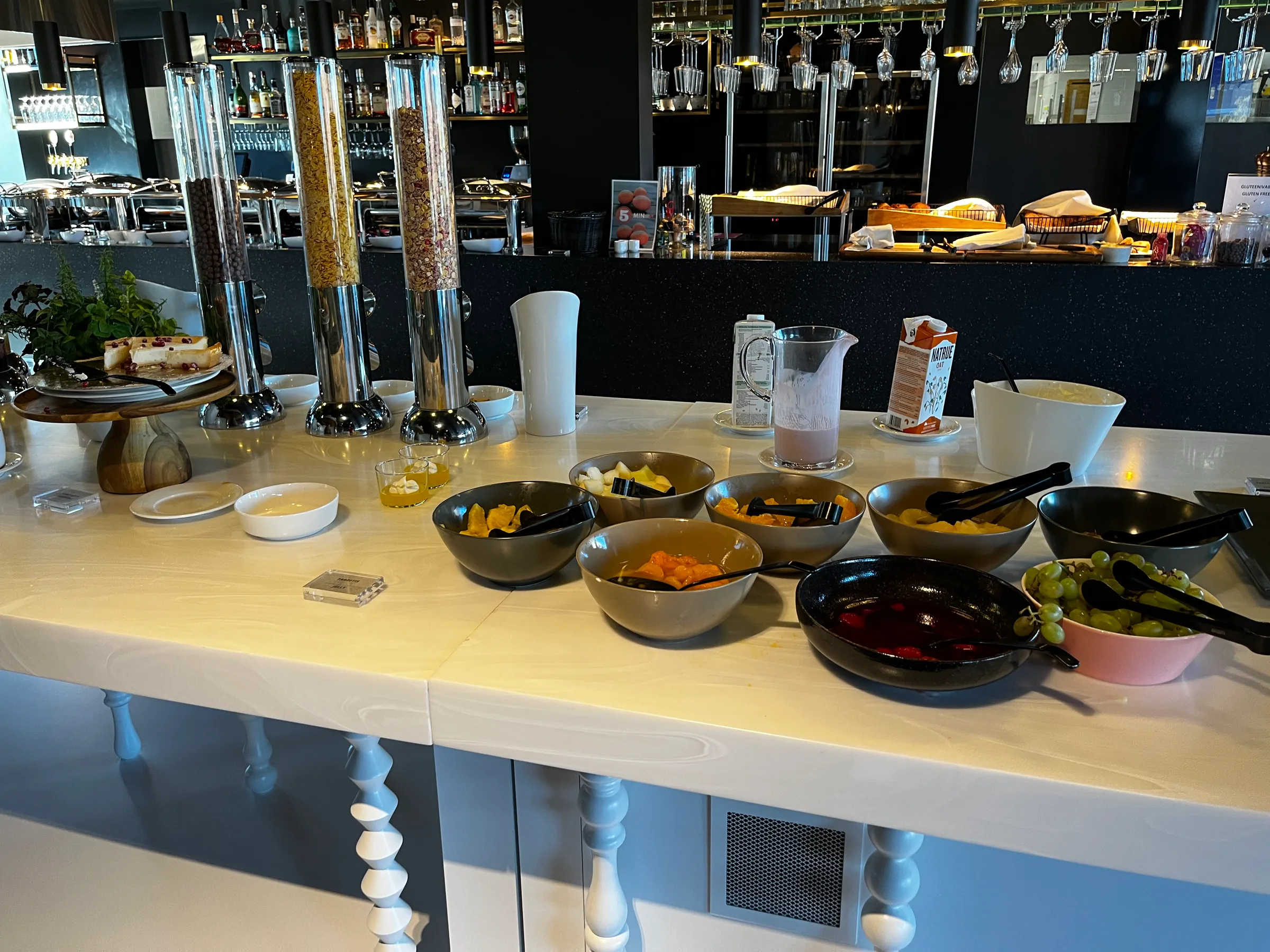 Frühstückstablett mit Obstschalen und Getränken auf weißer Bar