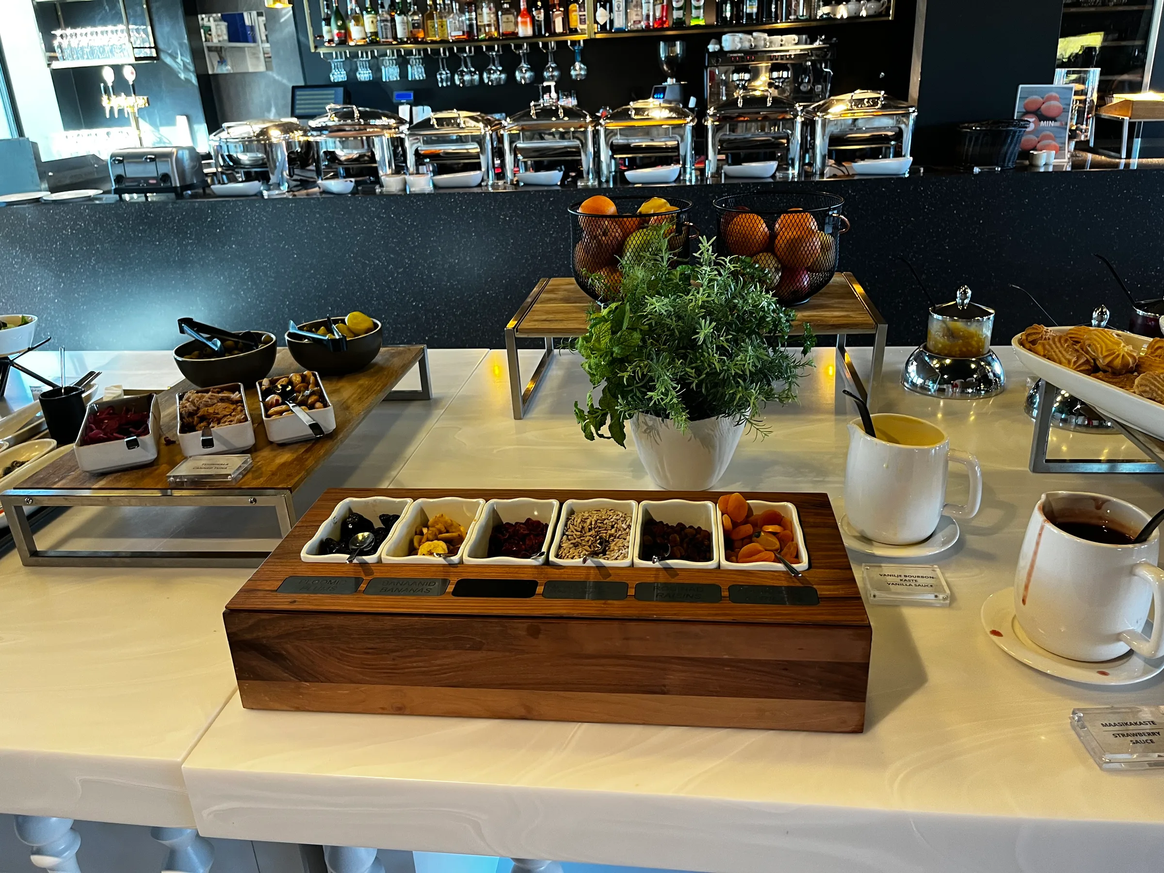 Frühstückstablett mit Obst, Nüssen und Kaffee auf weißem Tisch