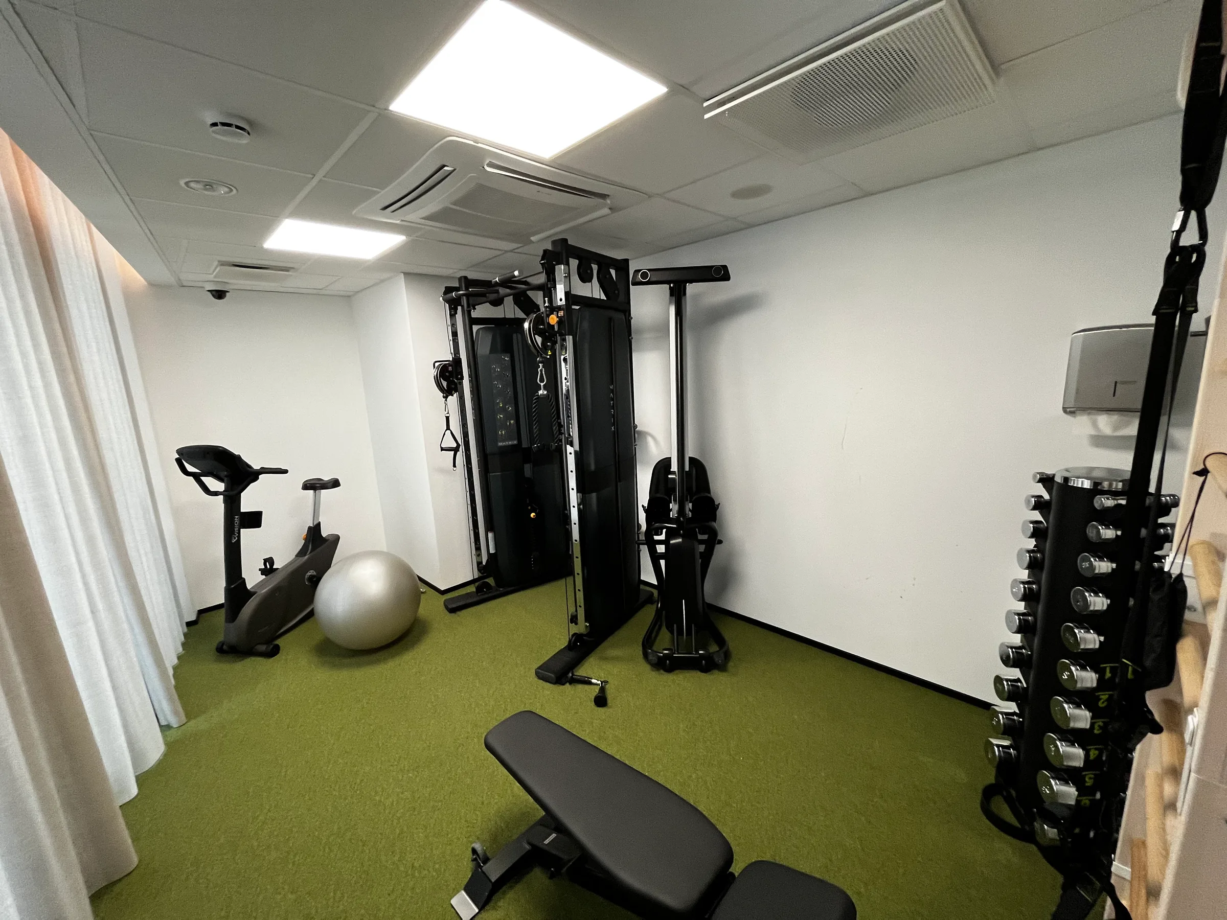 Fitnessraum mit Trainingsgeräten und Gewichten