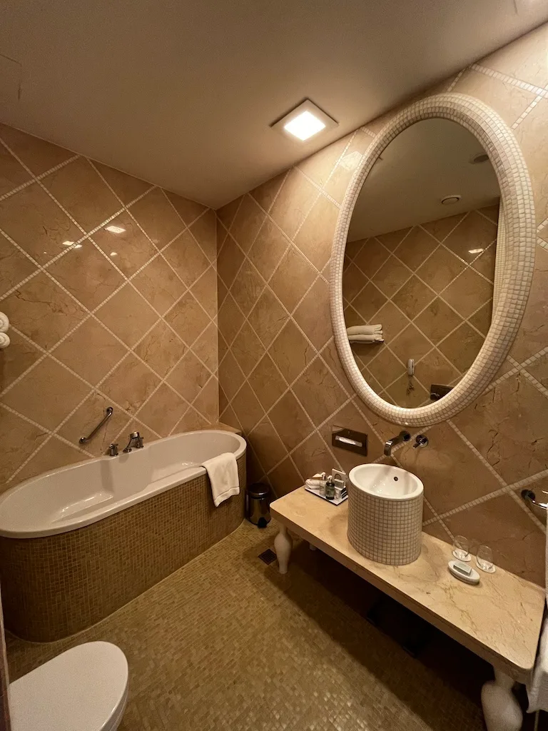 Hotelbad mit Badewanne, Waschbecken und Spiegel