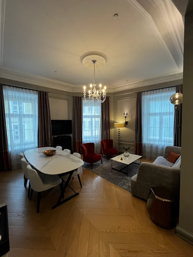 Hotelzimmer mit Esstisch, Stühlen und Sesseln in modernem Design