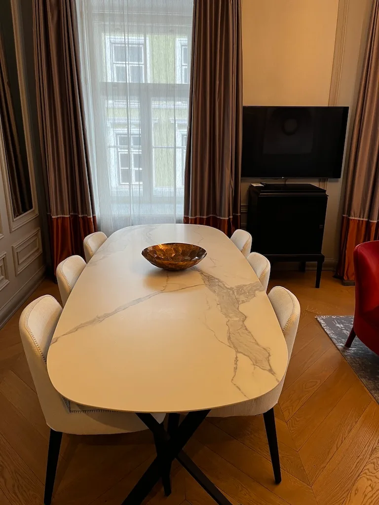 Hotelzimmer mit Esstisch und Stühlen in neutralen Farben