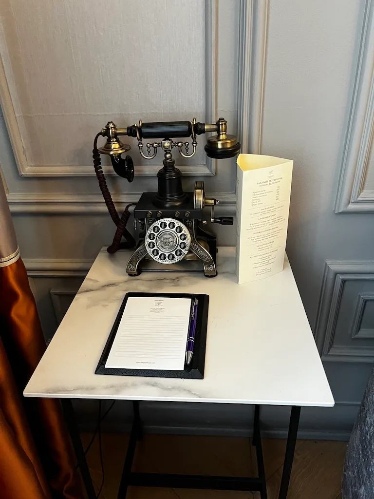 Hoteltelefon auf Marmortisch mit Notizblock und Stift