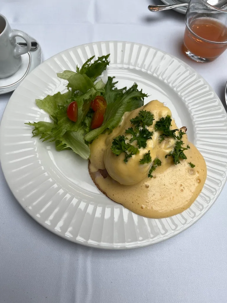 Eier mit Sauce Hollandaise auf Teller mit Salat