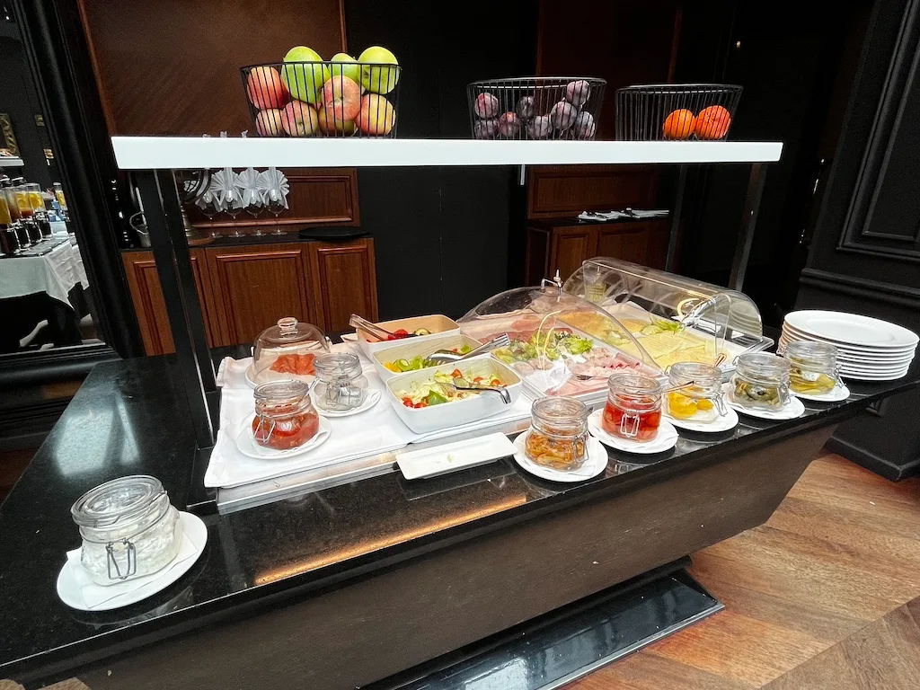 Frühstückstablett mit Salat, Obst und Honig auf Servierwagen