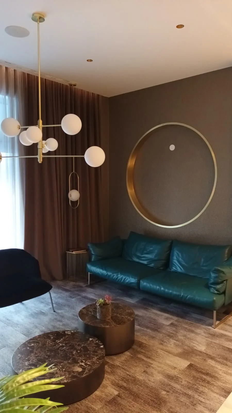 Lounge mit blauem Sofa und runder Wanddekoration
