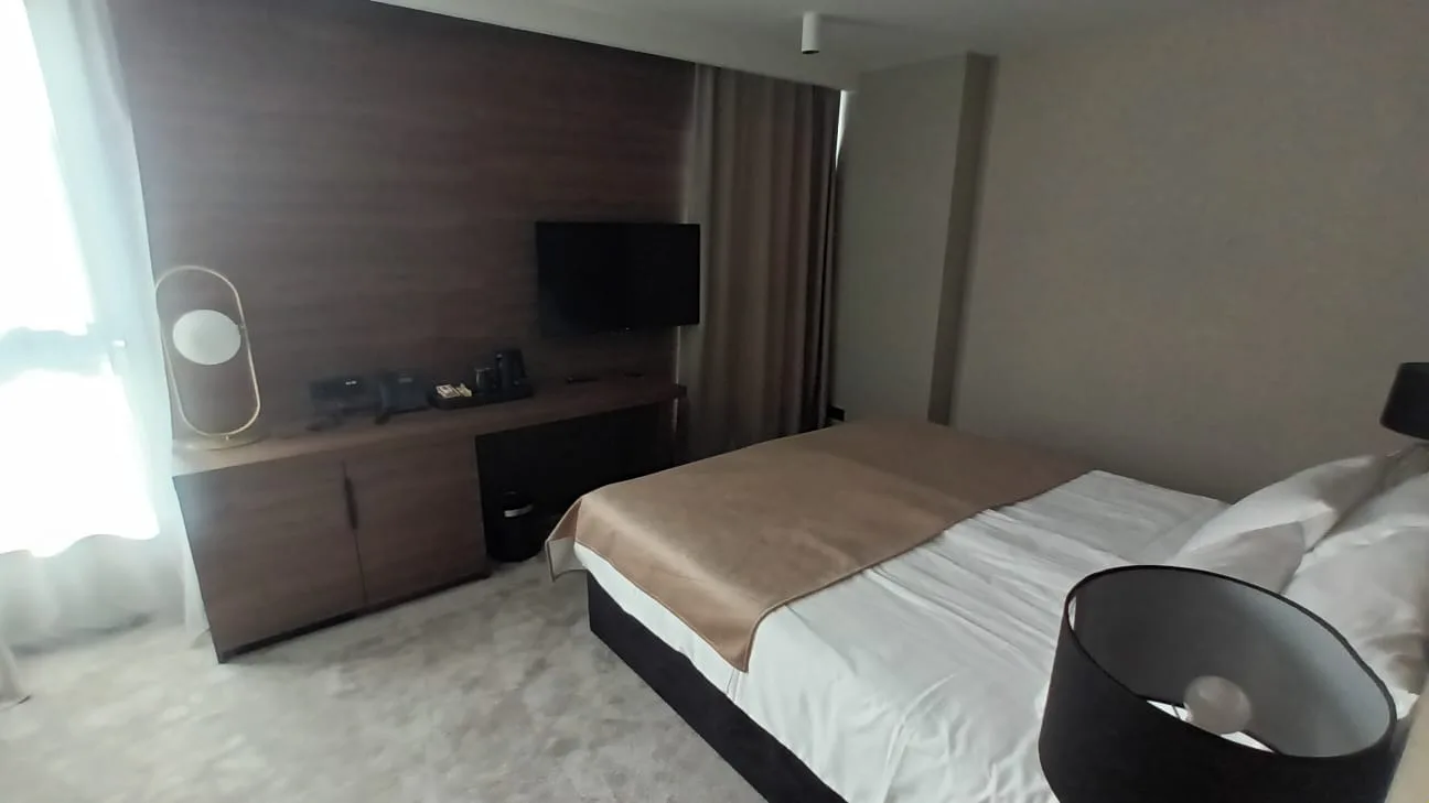 Hotelzimmer mit Doppelbett und Flachbildfernseher
