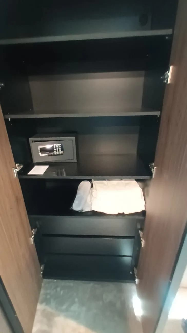 Schrank mit Safe und Handtuch im Hotelzimmer