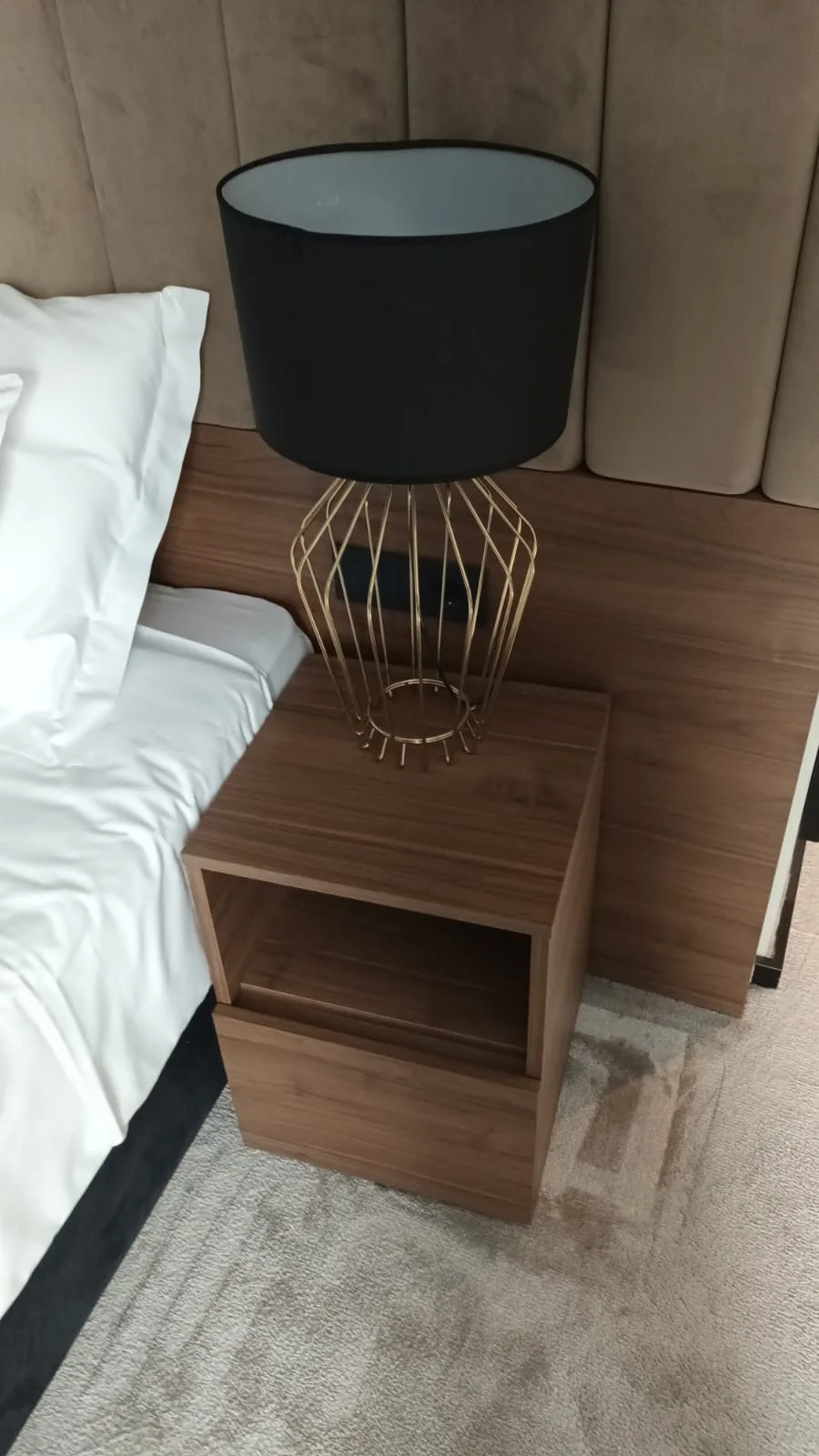 Nachtisch mit Lampe und Bett im Hotelzimmer