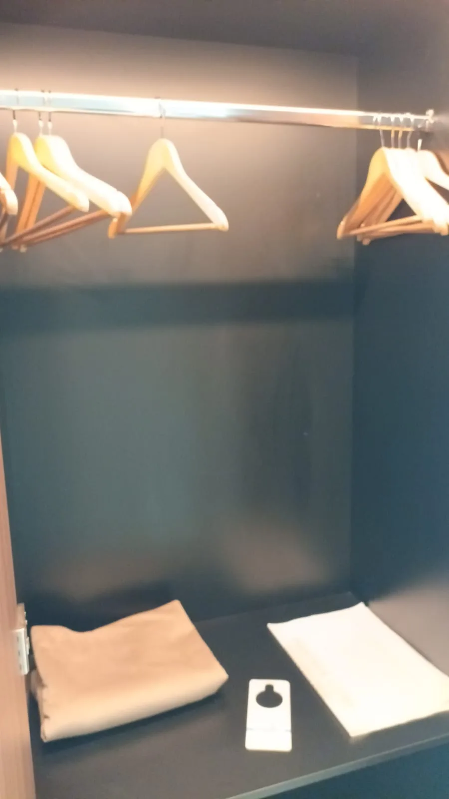 Schrank mit Kleiderbügeln und Handtüchern im Hotelzimmer