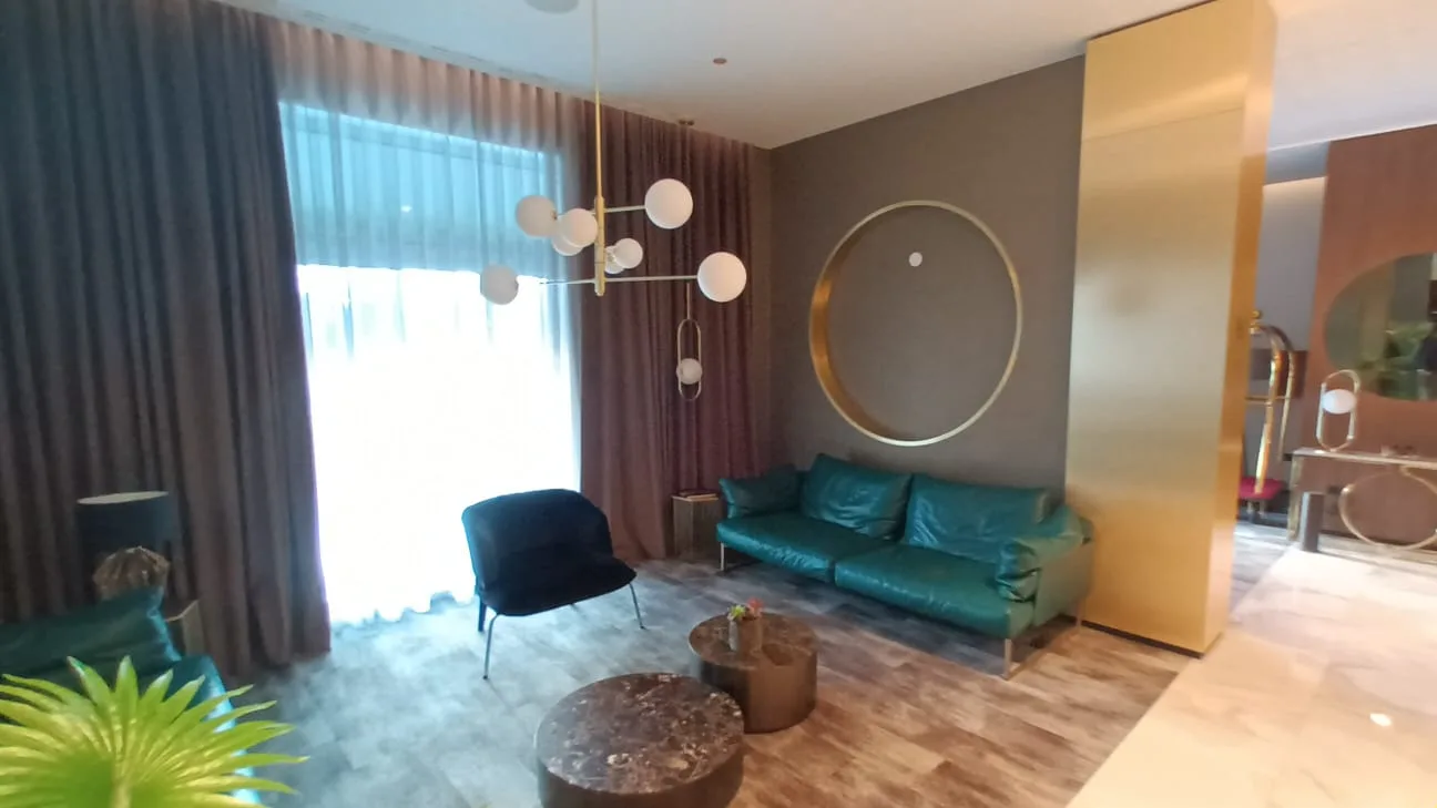 Lounge mit grüner Ledercouch und moderner Pendelleuchte