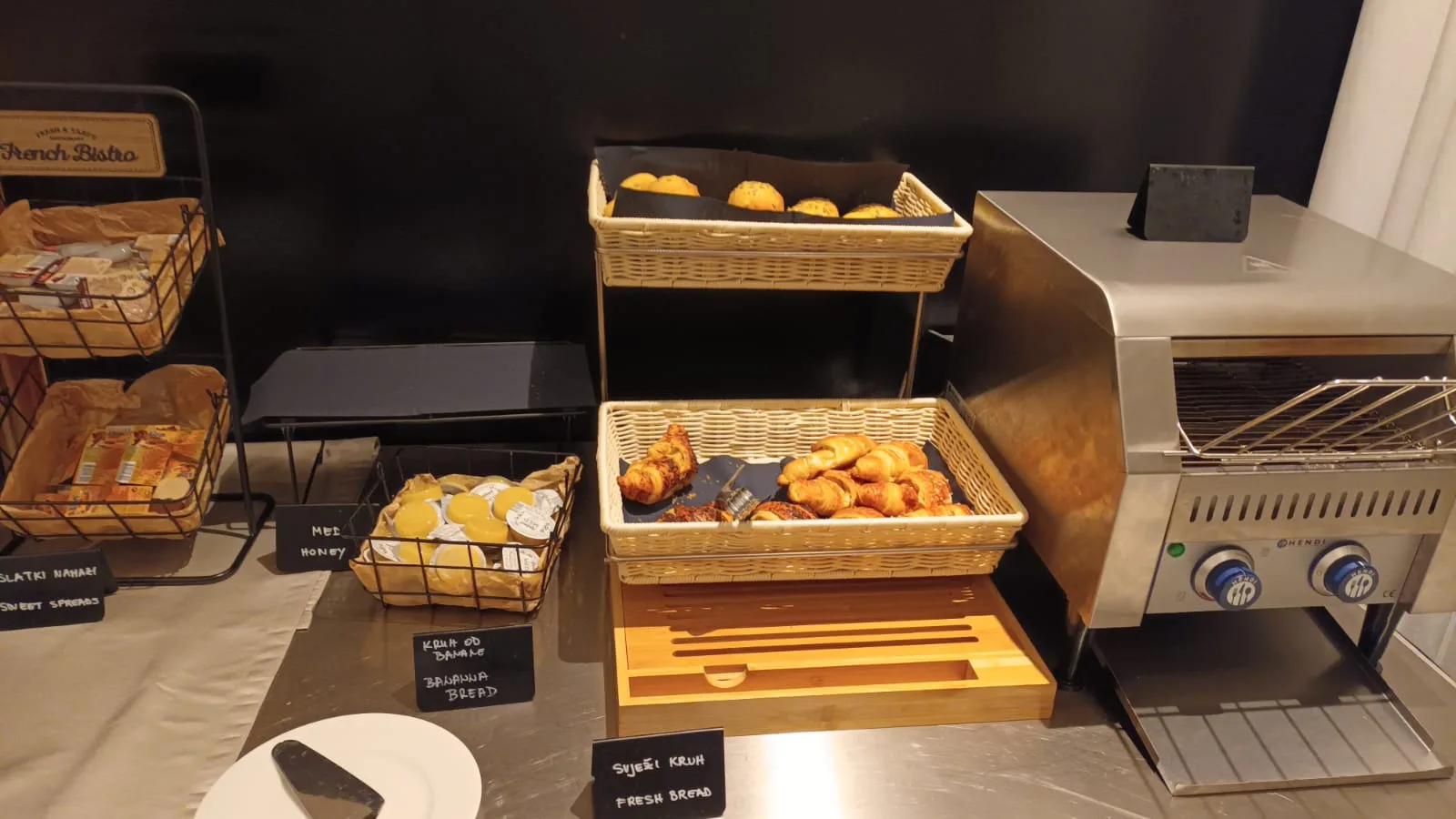 Frühstückstisch mit Körben voller Gebäck und Kaffeezubehör