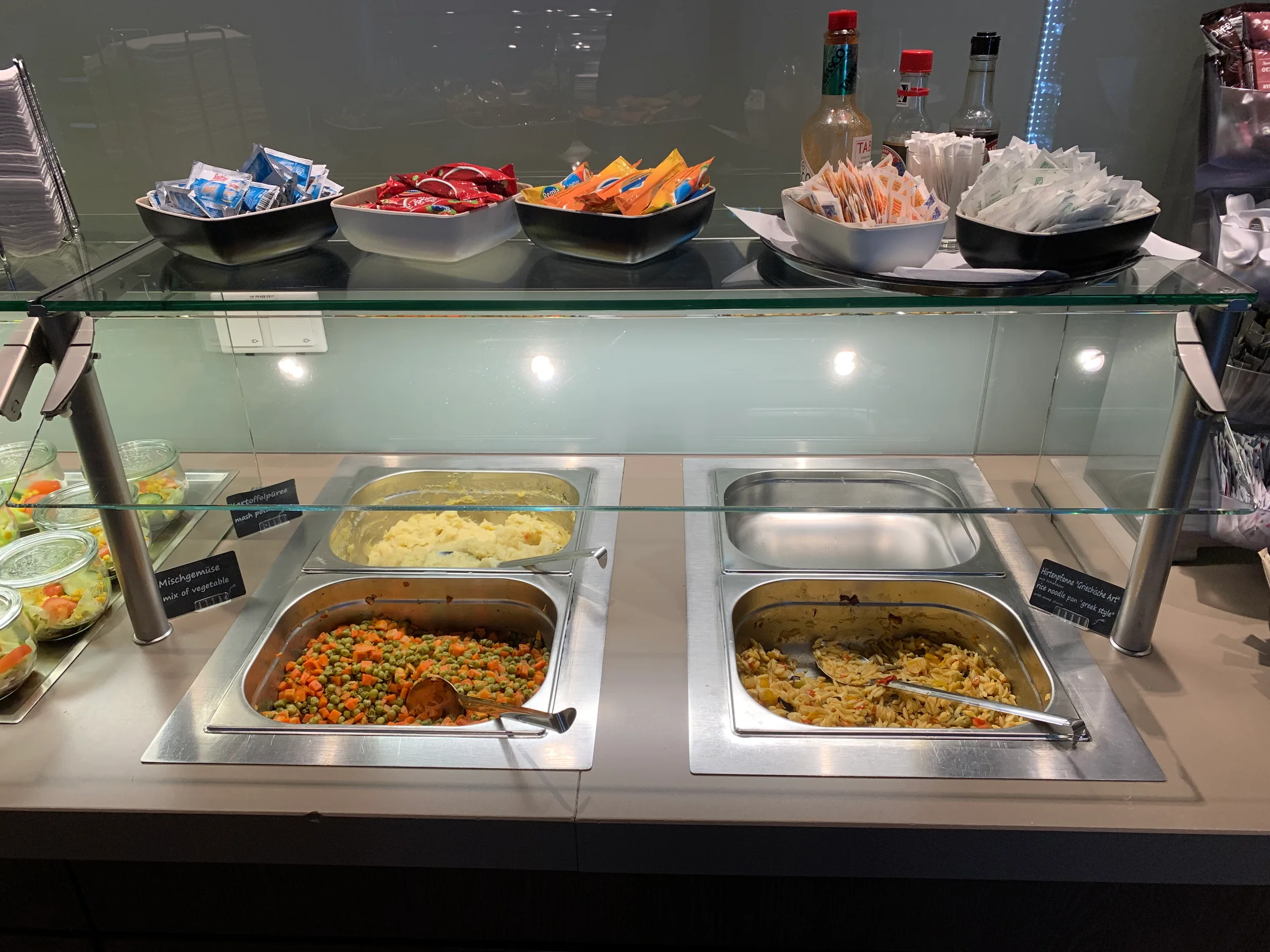 Buffet mit Salat, Gemüse und Reis im Flughafenlounge während Corona