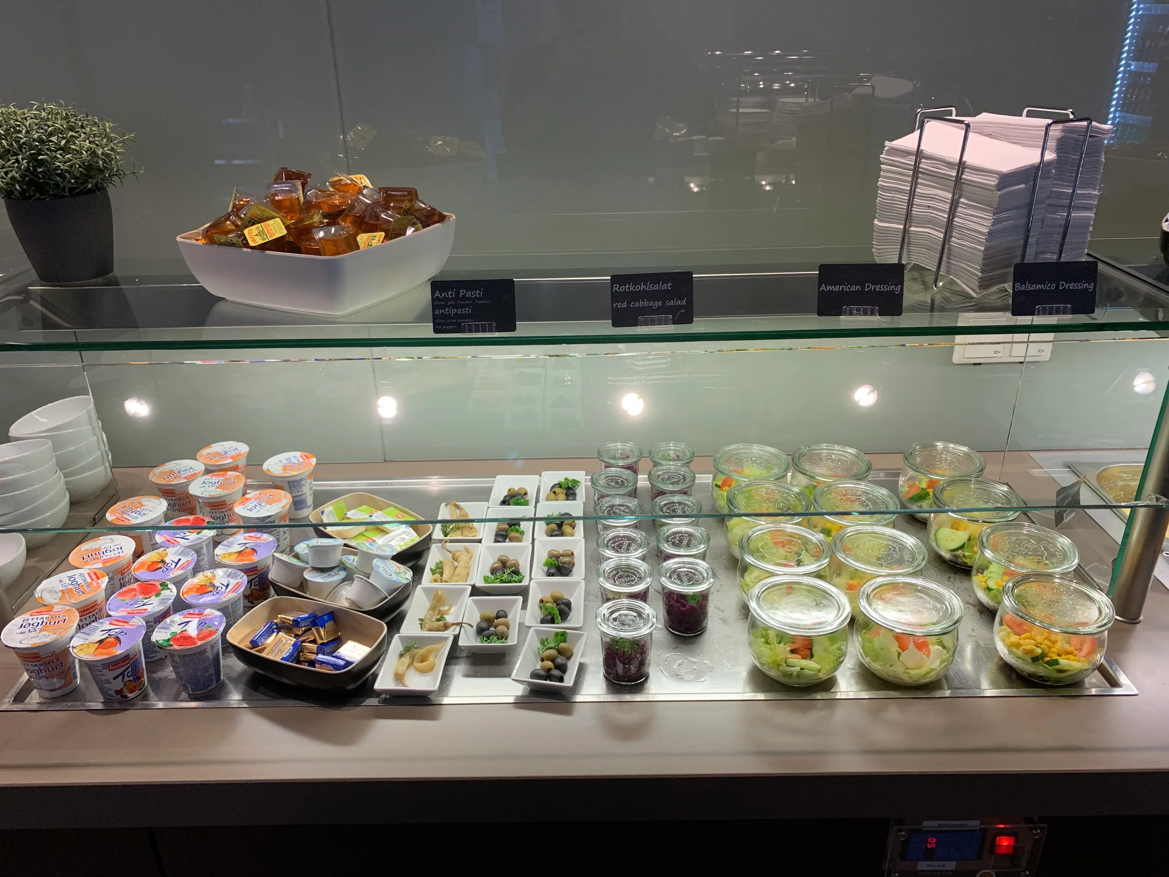 Salatbar mit verschiedenen Salaten und Beilagen auf einer Glasscheibe