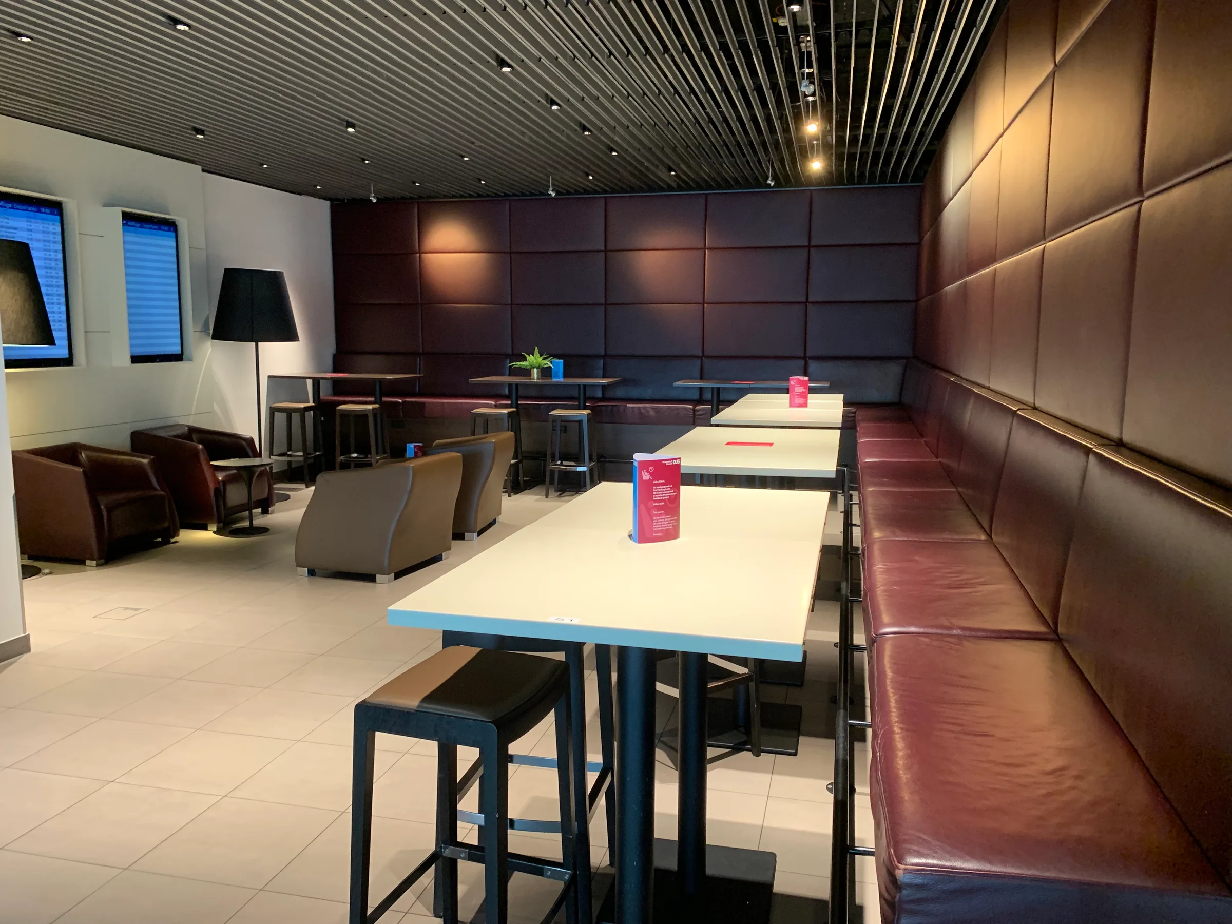 Lounge mit Sitzbänken und Tischen in warmen Farbtönen