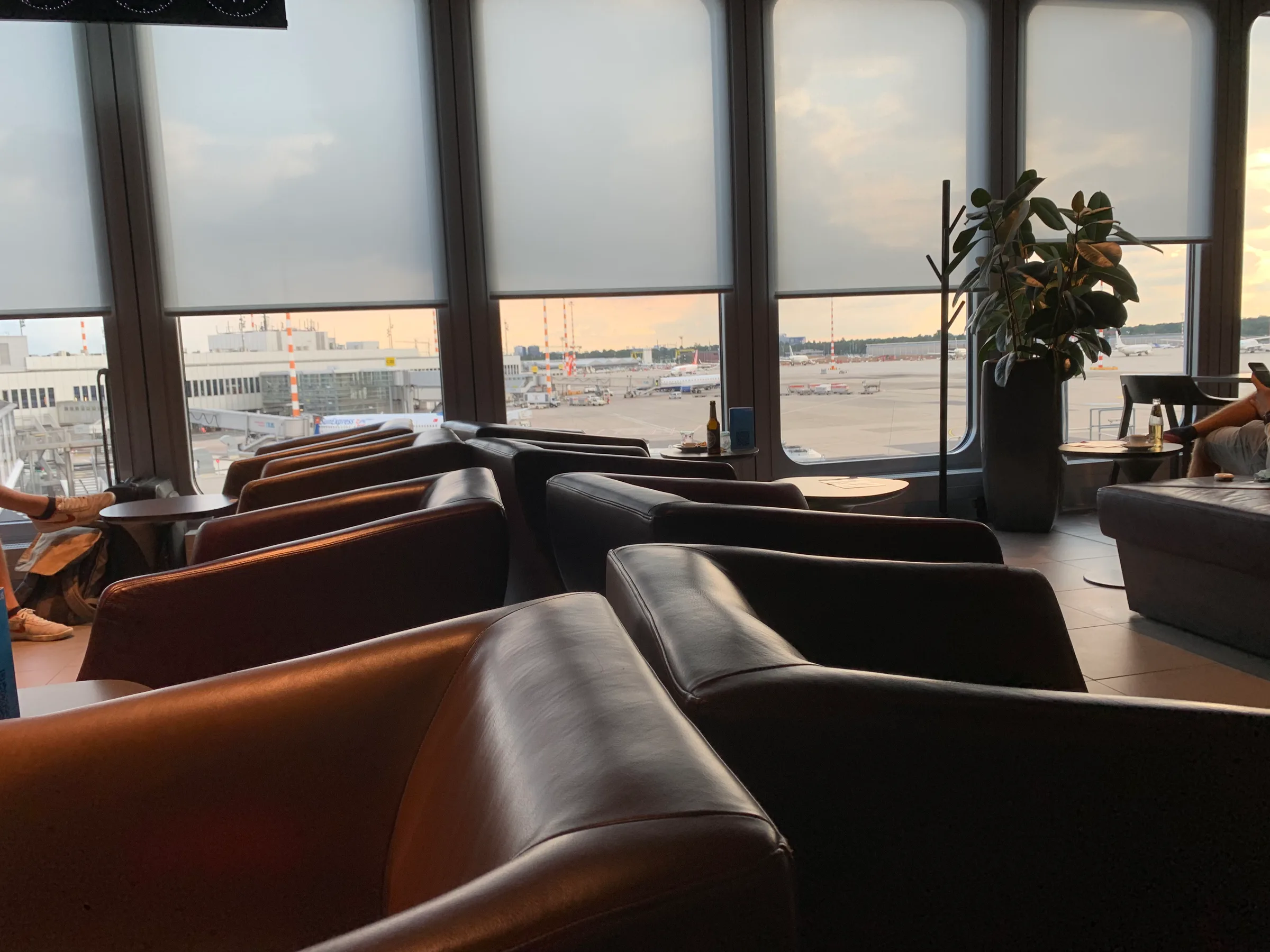 Lounge mit Sesseln und Tischen am Flughafenfenster