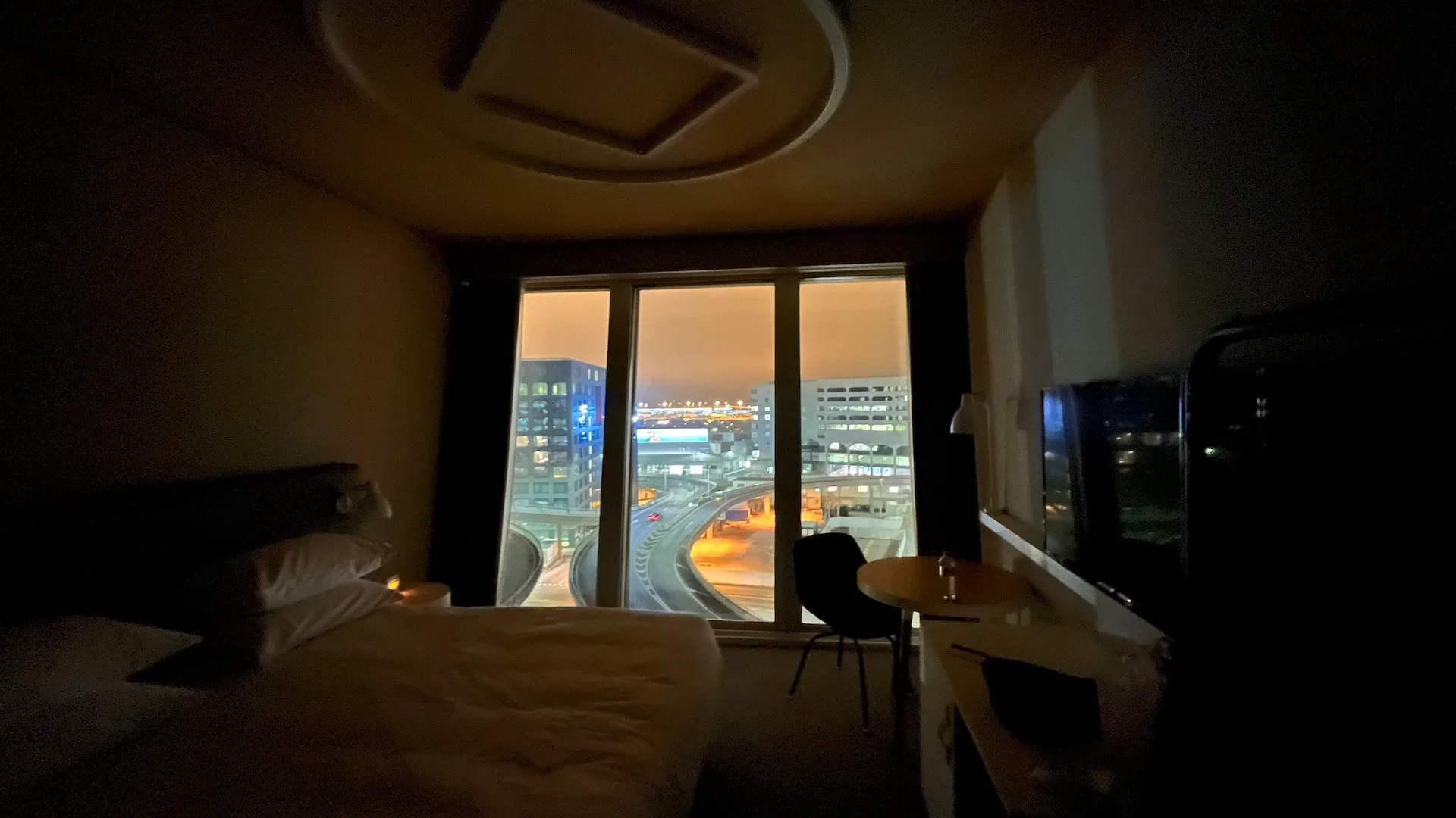 Hotelzimmer mit Doppelbett und Tagesdecke in Grautönen