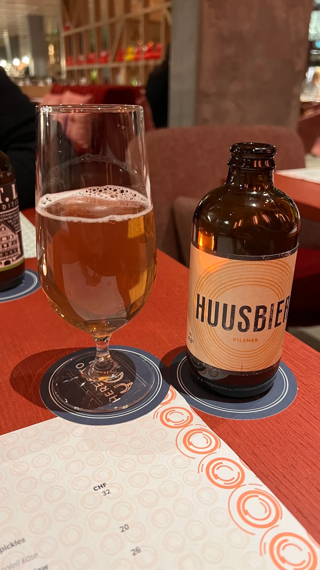 Bierglas und Flasche Huusbier Pilsner auf Tisch