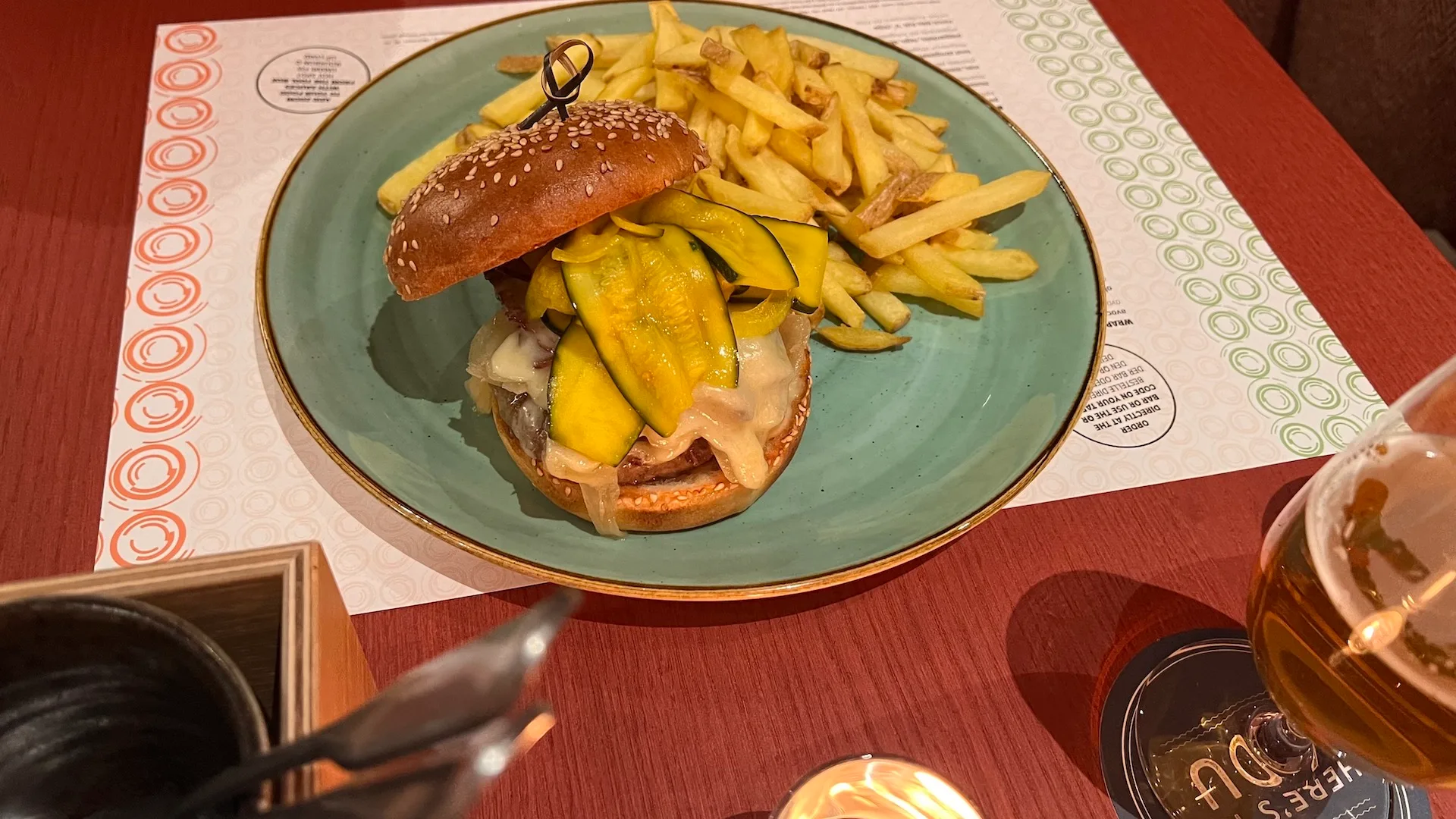 Hamburger mit Zucchini und Pommes frites auf blauem Teller