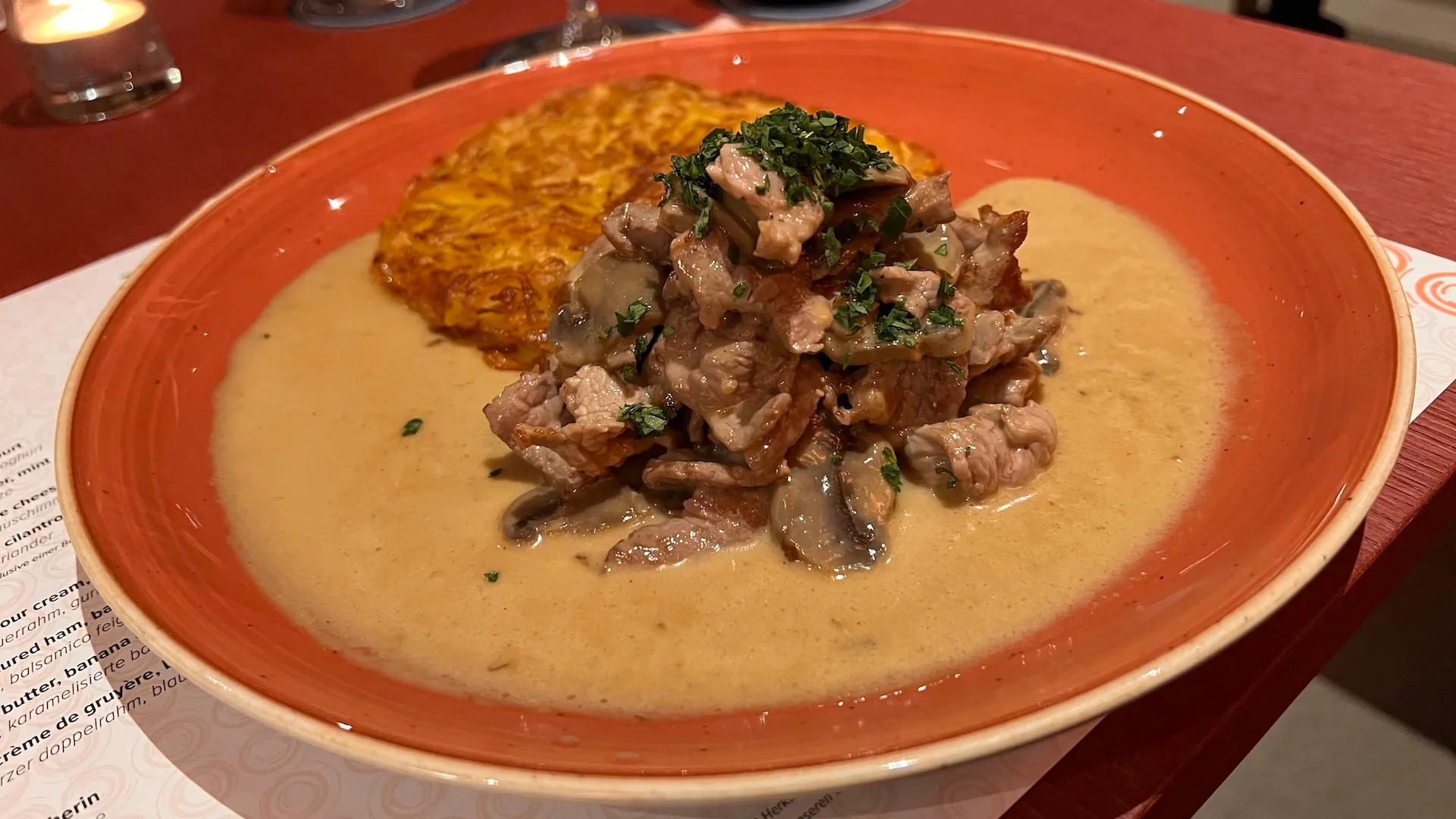 Gedeckter Teller mit Suppe, Pilzen und Kräutern