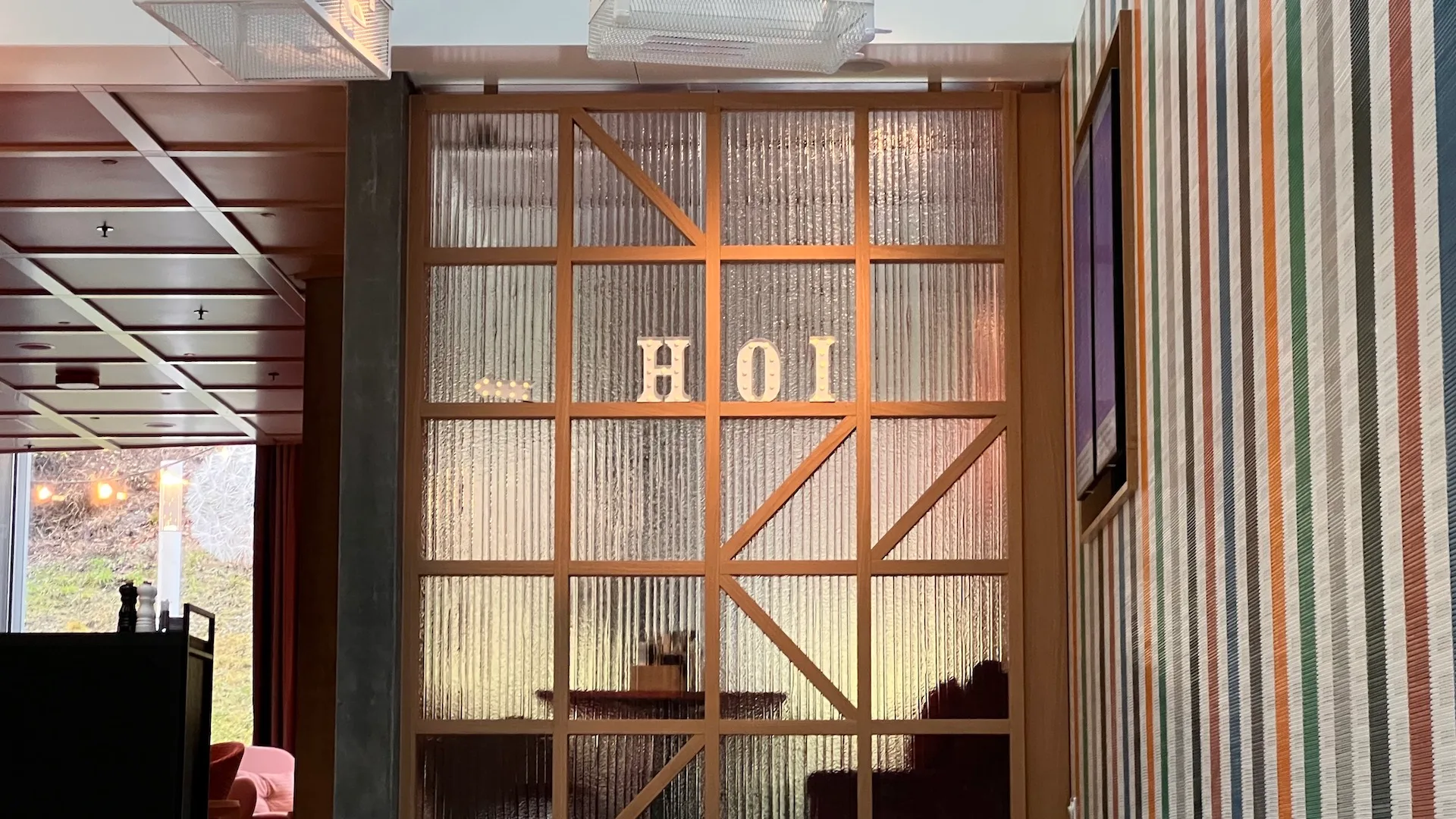 Eingangsbereich eines Hotels mit Holzrahmen und Text "HOI"