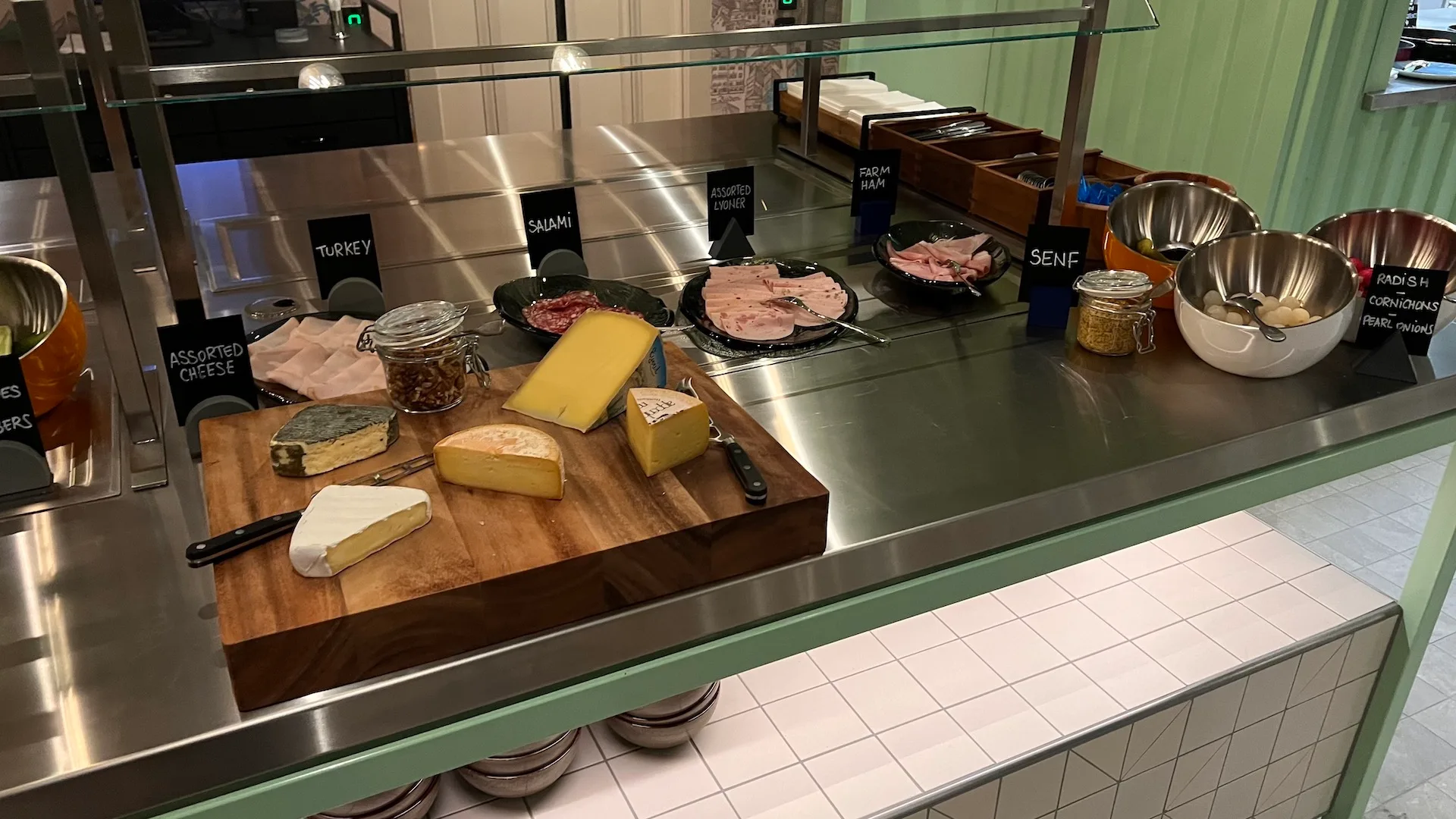 Käsebuffet mit verschiedenen Käsesorten und Wurstwaren auf Edelstahlplatte