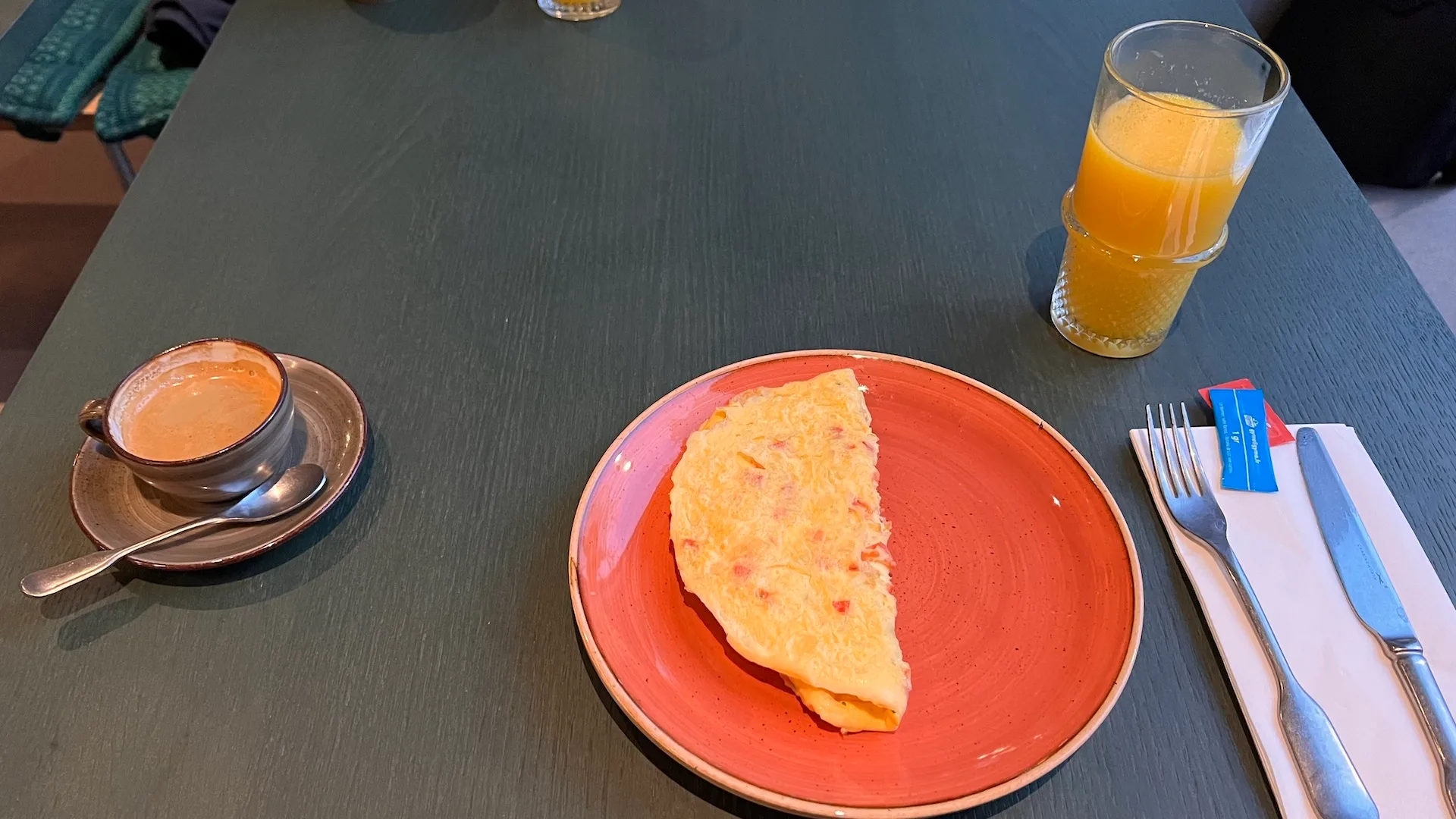 Frühstücksteller mit Eiern, Kaffee und Orangensaft auf Tisch