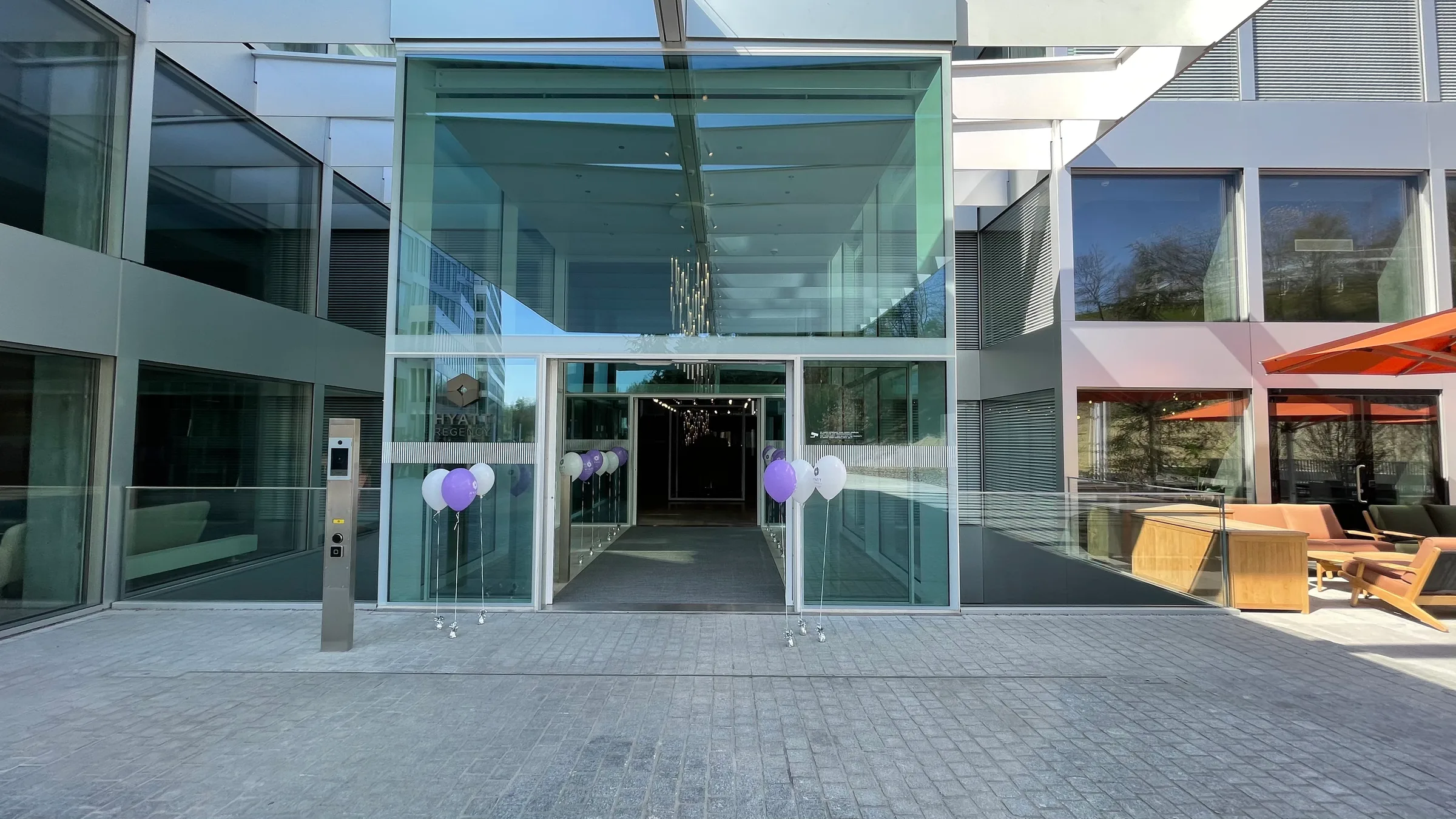 Eingangsbereich eines modernen Hotels mit Glasfassade und Luftballons