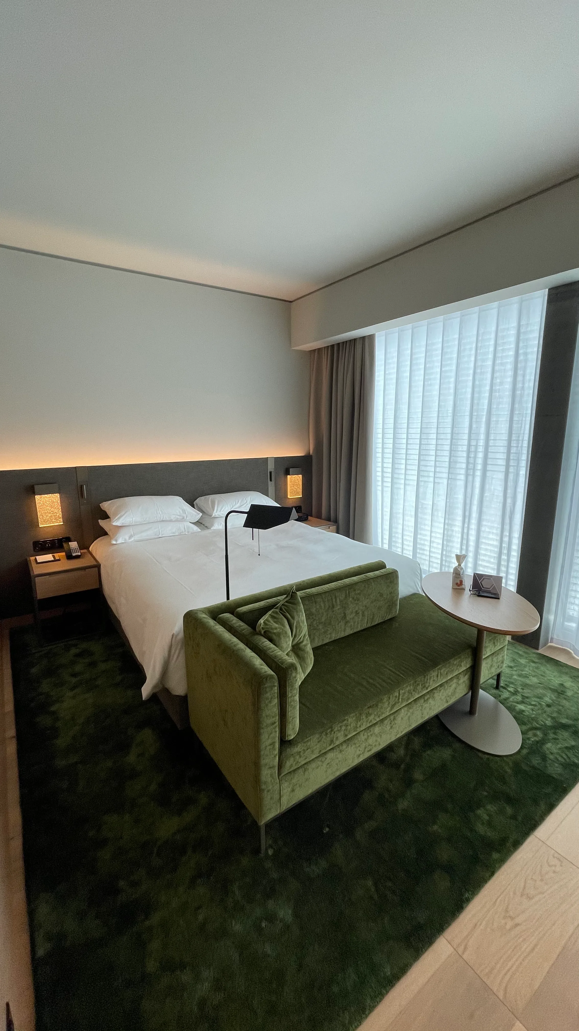 Hotelzimmer mit Doppelbett und grüner Couch