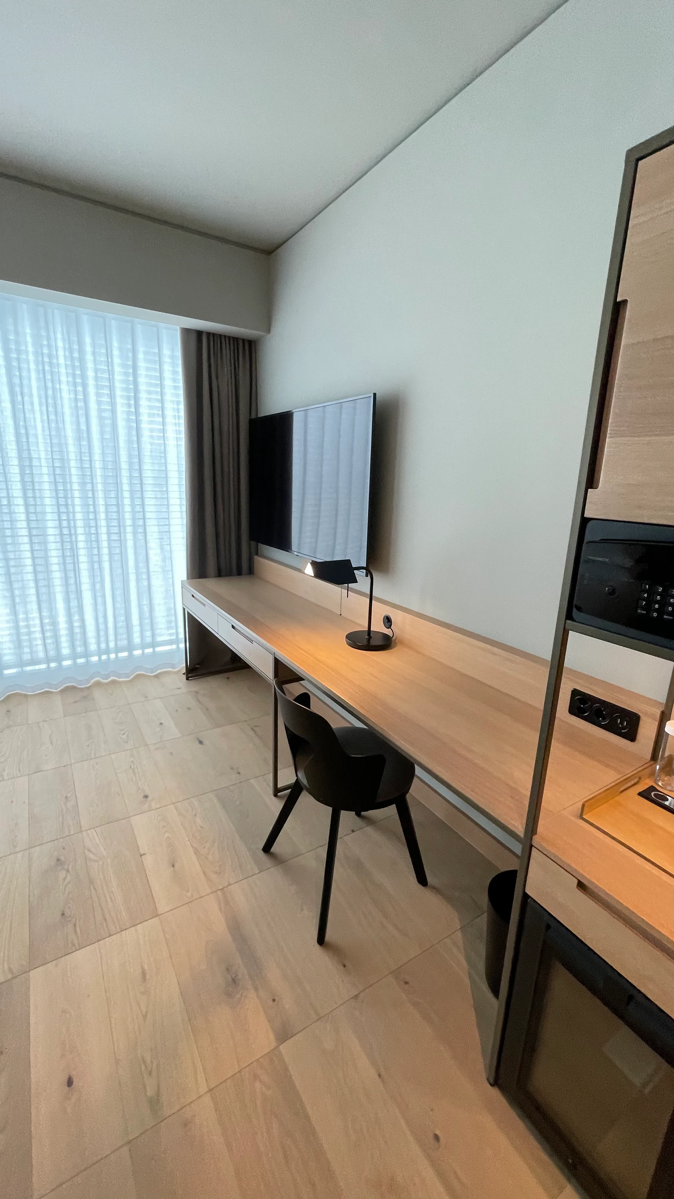 Hotelzimmer mit Schreibtisch und Fernseher an der Wand