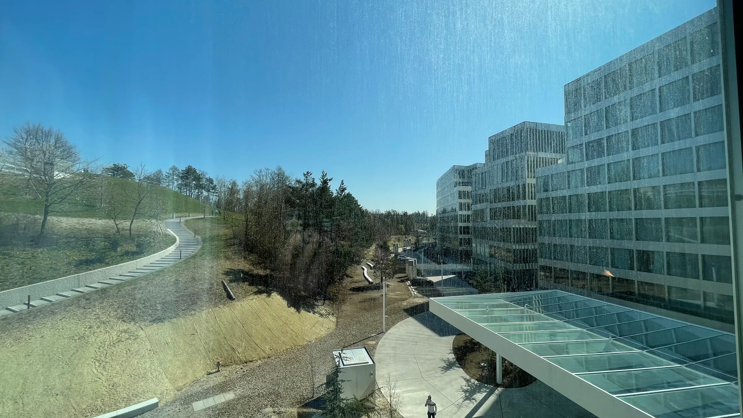 Fachwerkgebäude mit Glasbrücke und Parkanlage im Hintergrund