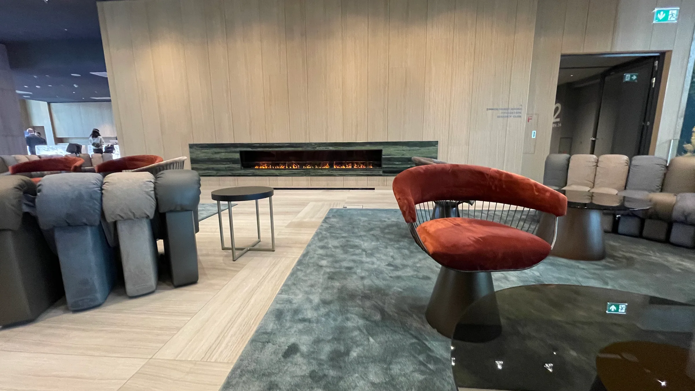 Lounge mit Sesseln und Kamin im Flughafen-Hotel