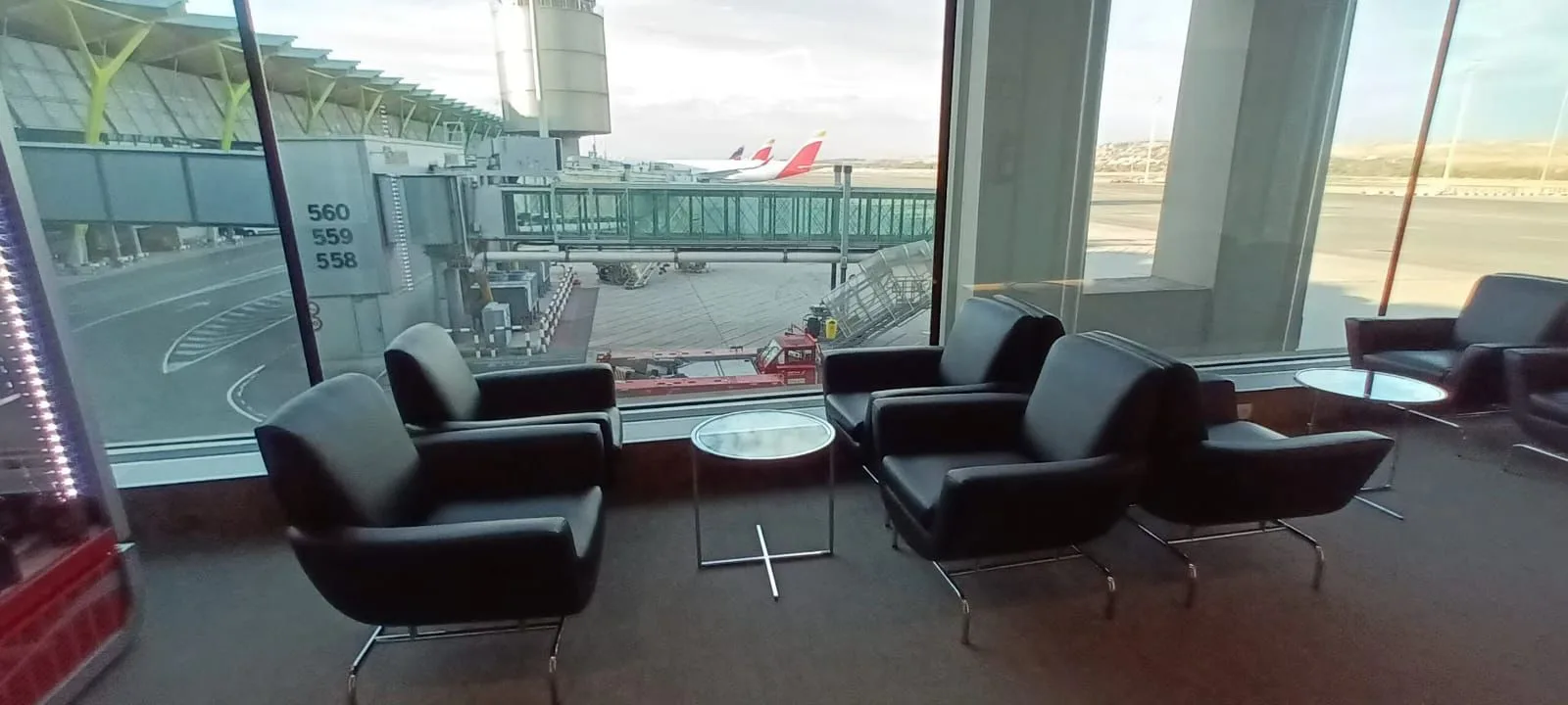 Premium-Lounge mit Sesseln und Blick auf Flughafen
