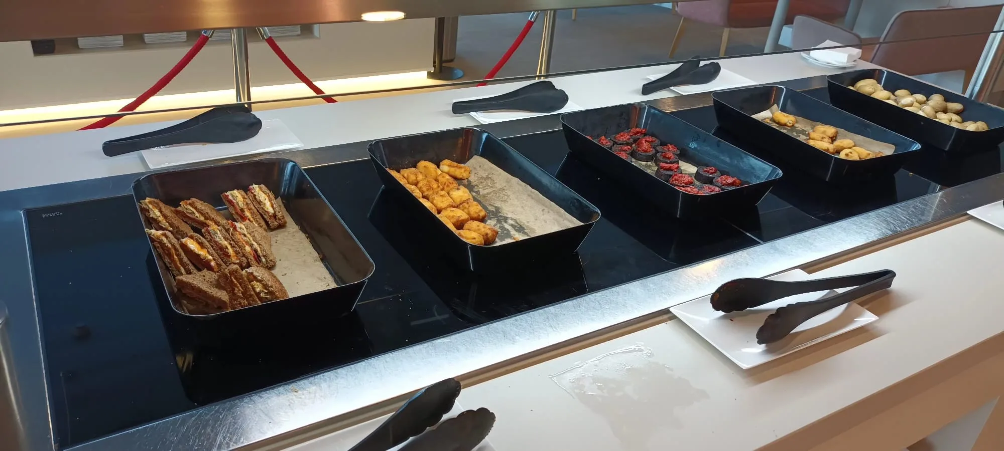 Buffet mit verschiedenen Snacks und Desserts auf schwarzen Schalen