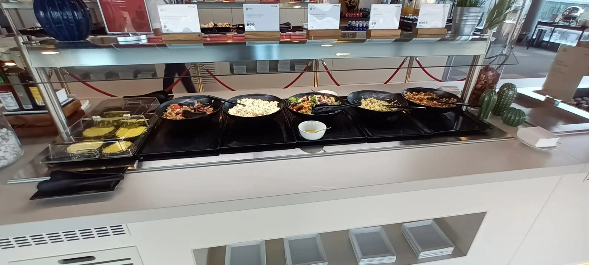 Buffet mit verschiedenen Gerichten in Pfannen auf einem Metalltisch