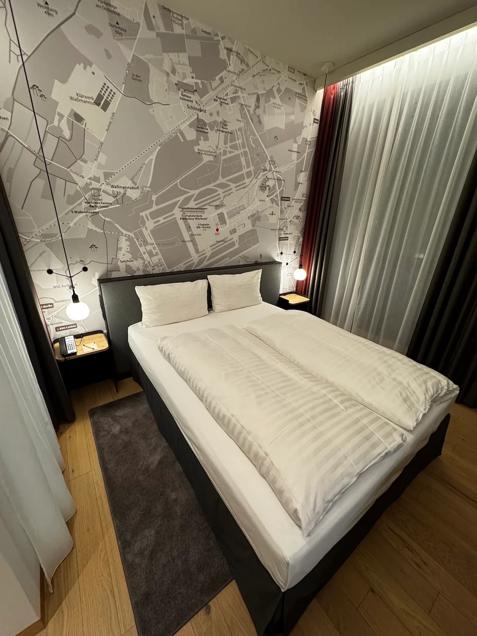 Hotelzimmer mit Doppelbett und Karte an der Wand