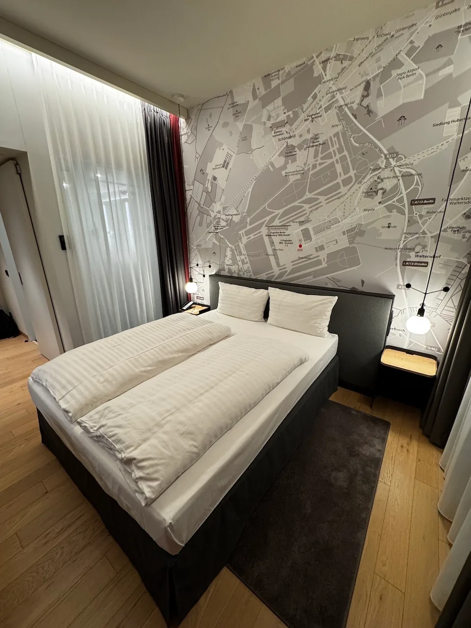 Hotelzimmer mit Doppelbett und Stadtplan an der Wand