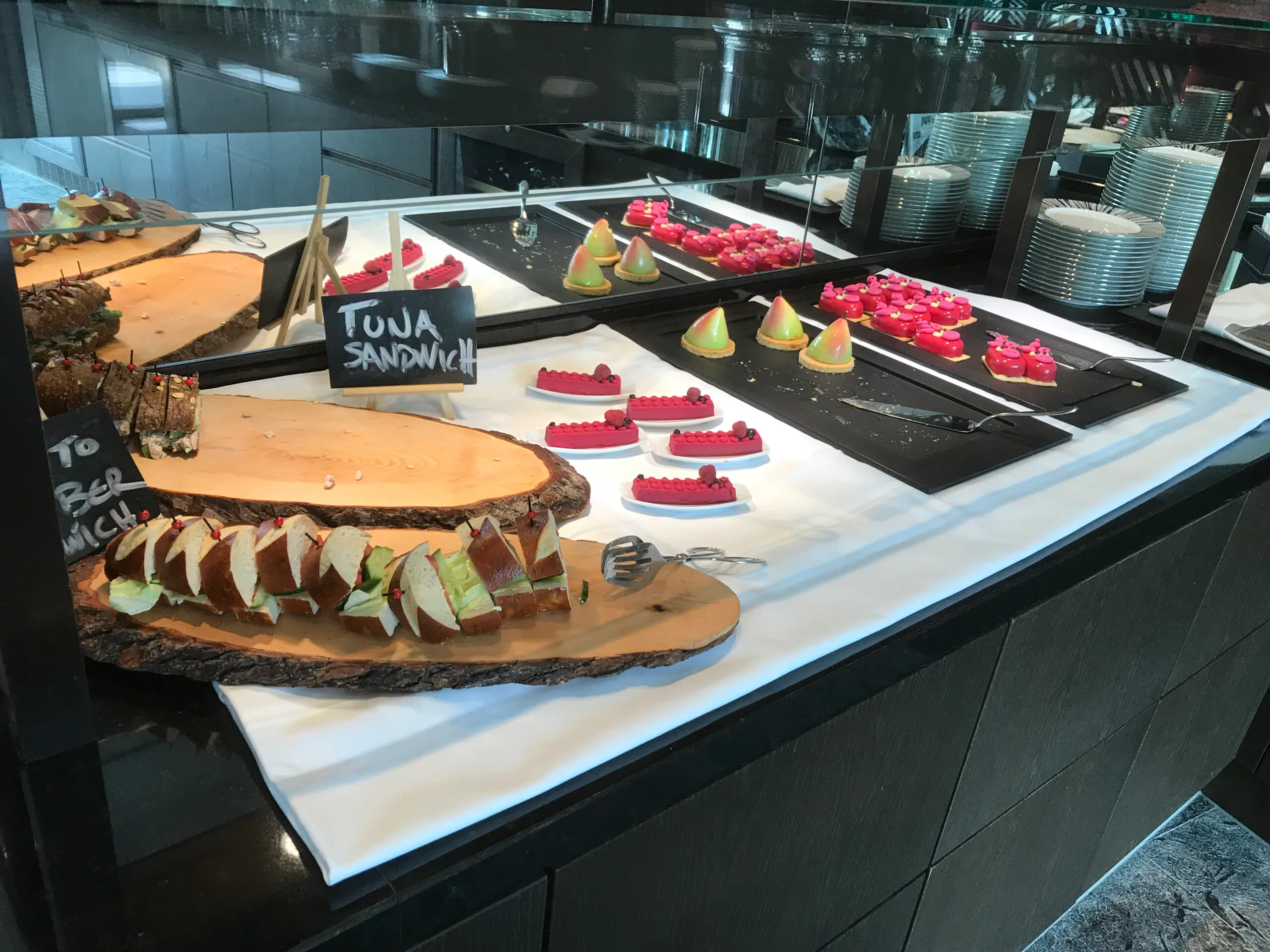 Buffet mit Sandwichen und Kuchen auf Holzbrettern