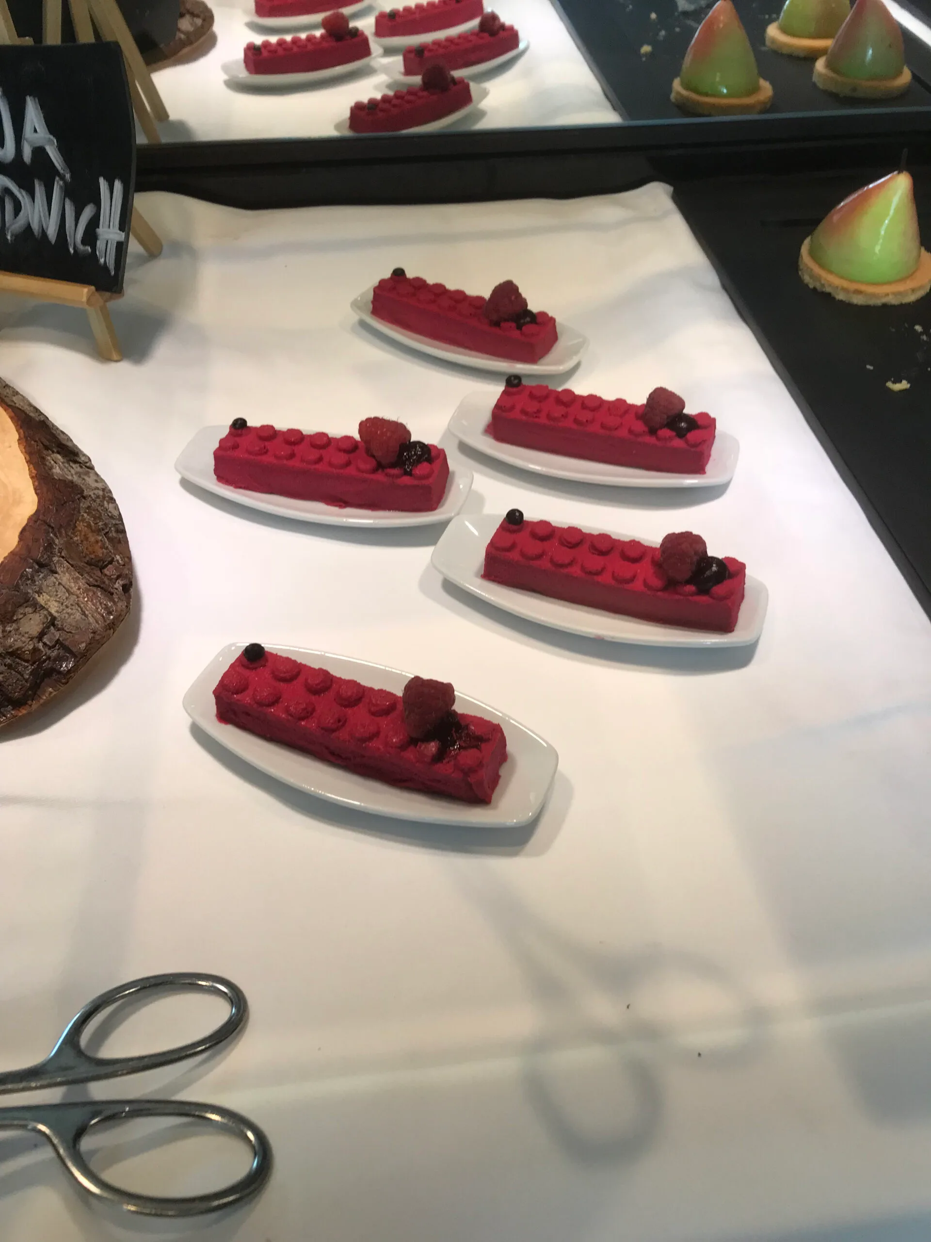 Rote Desserts auf weißen Tellern mit Himbeeren